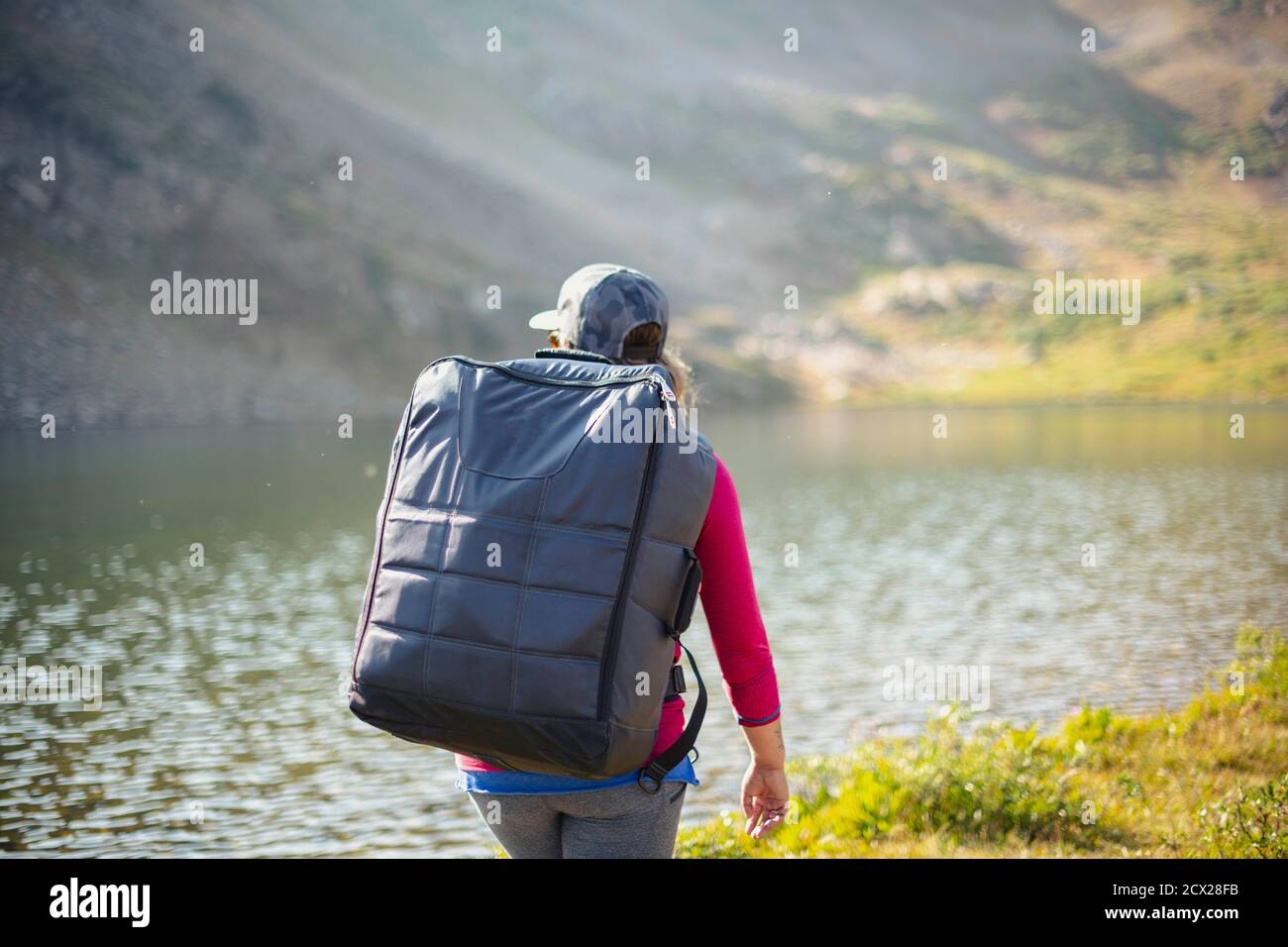 Rear view of backpacker at lakeshore during summer Stock Photo - Alamy