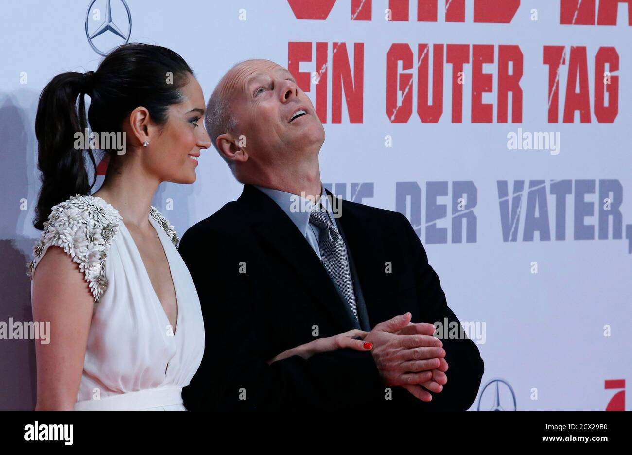 Actor Bruce Willis and his wife Emma Heming pose on the red carpet for the premiere of the movie 'Stirb Langsam - Ein Guter Tag zum Sterben' (A Good Day to Die Hard) in Berlin February 4, 2013. The movie opens in German cinemas on February 14. REUTERS/Tobias Schwarz (GERMANY - Tags: ENTERTAINMENT) Stock Photo