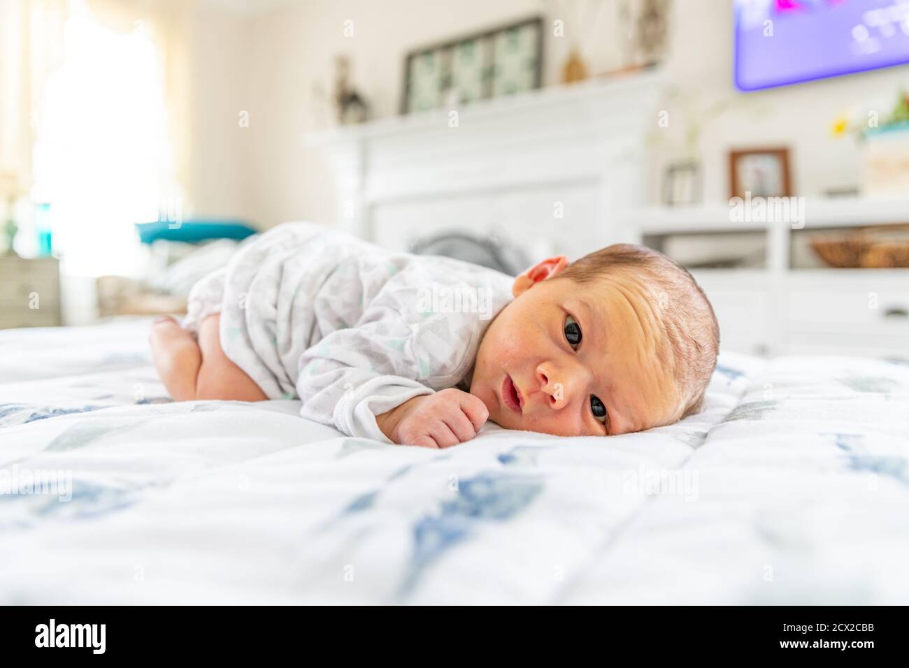 New born baby laying on stomach with eyes crossed Stock Photo Alamy