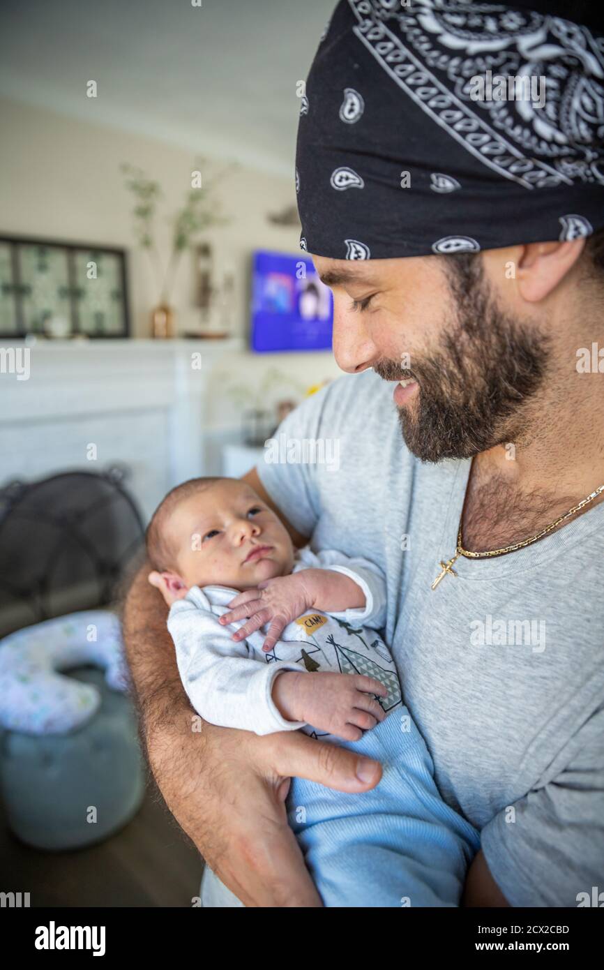 Proud father looking down at newborn son. Stock Photo