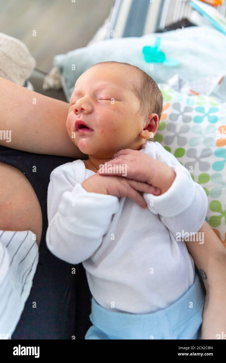 New born baby sleeping peacefully in mother's arms Stock Photo Alamy