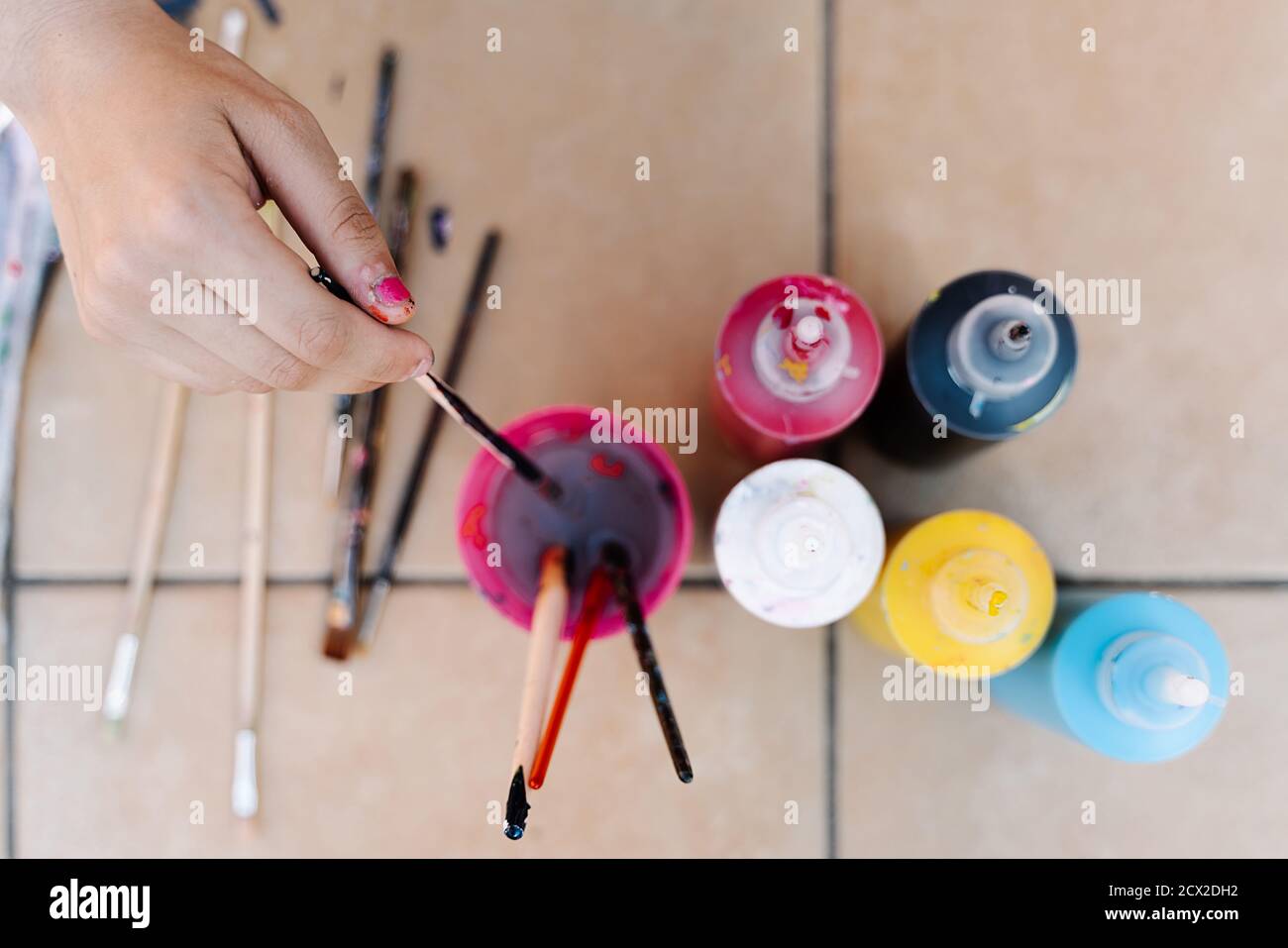 hand removing a brush in the water to clean the color painting with