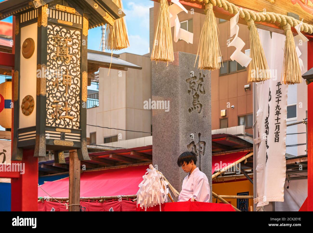 asakusa, japan - november 08 2019: Young Japanese Negi boy dressed in traditional jōe kimono blessing the faithful with an Ōnusa at the Shinto Ootori Stock Photo