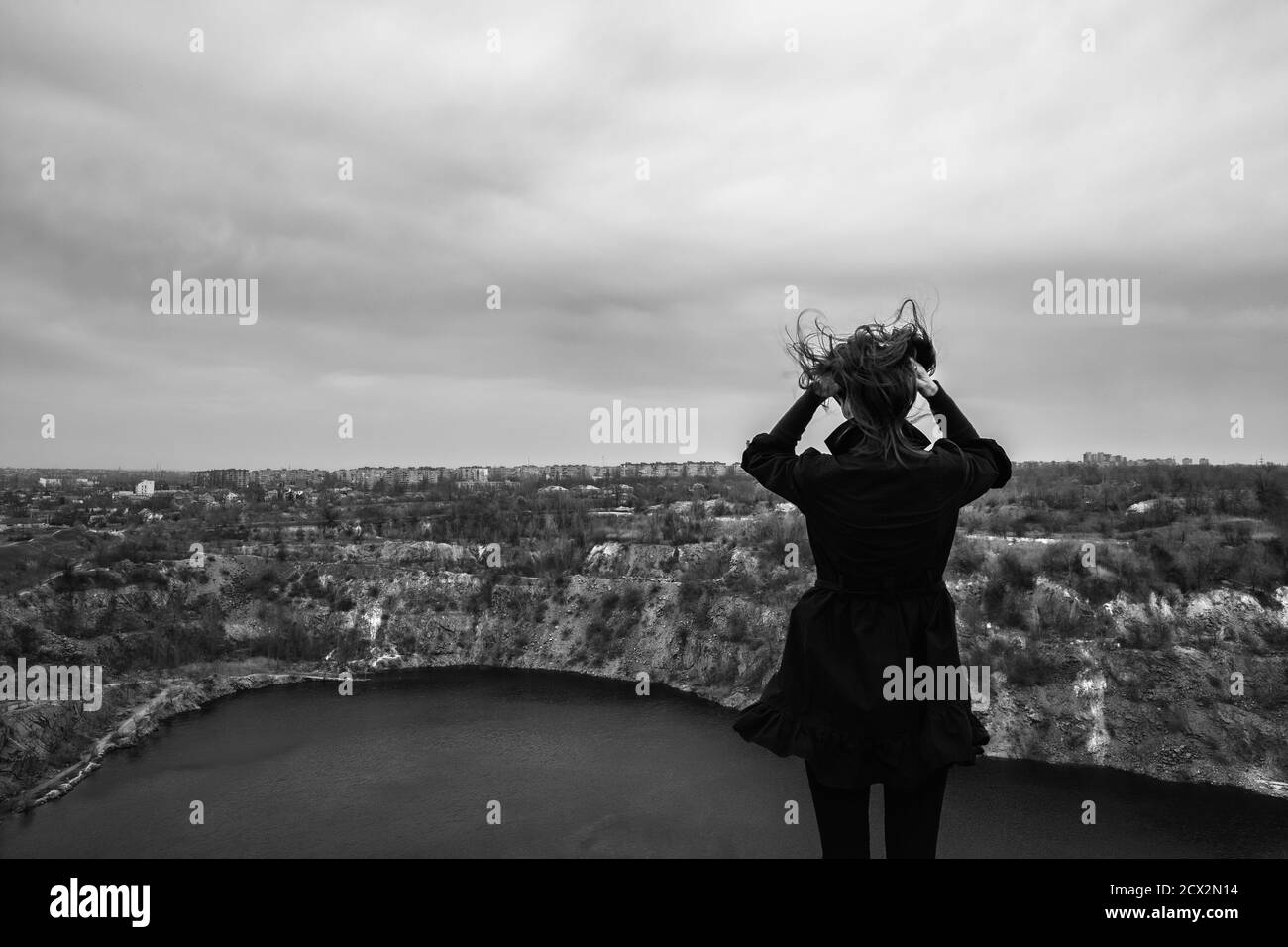 The girl on the landscape background doing she&rsquo;s hair. At the windy