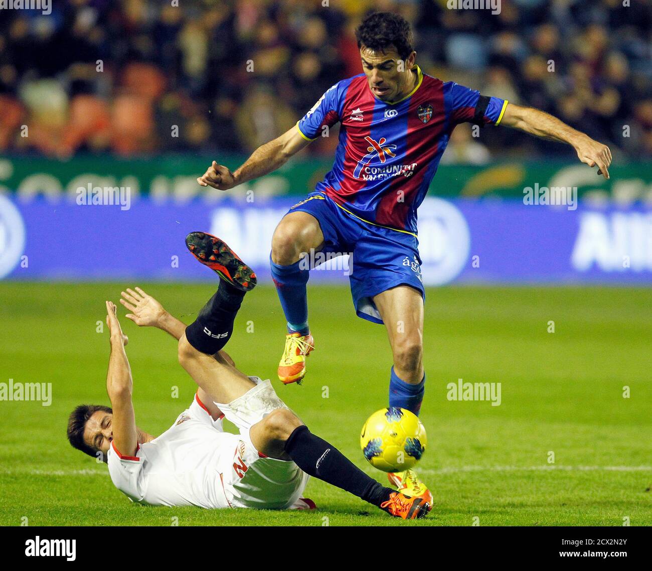 Levante's Xavi Venta controls the ball over Sevilla's Manu del Moral (on ground) during their Spanish first division soccer match at the Ciudad de Valencia Stadium in Valencia December 10, 2011. REUTERS/Heino Kalis (SPAIN - Tags: SPORT SOCCER) Stock Photo