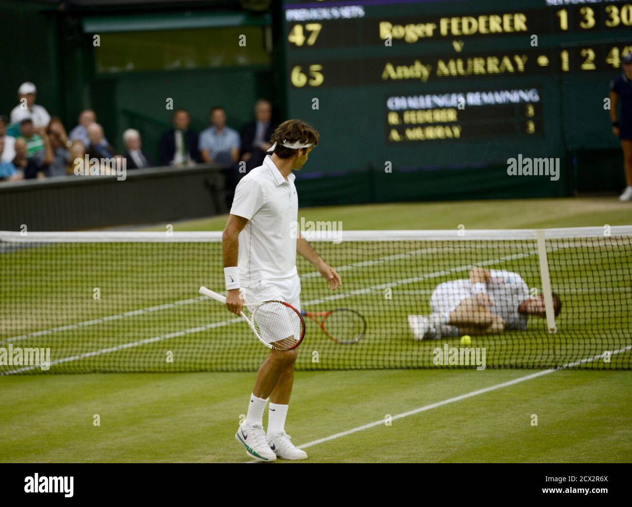 Roger Federer of Switzerland (L) walks away from the net as Andy Murray of  Britain slips during their men's singles final tennis match at the Wimbledon  Tennis Championships in London July 8,