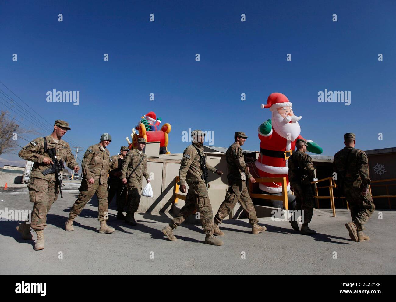 NATO troops from the International Security Assistance Force (ISAF) walk during Christmas celebrations at Bagram Airfield, north of Kabul, December 25, 2013. REUTERS/Mohammad Ismail (AFGHANISTAN - Tags: MILITARY SOCIETY) Stock Photo