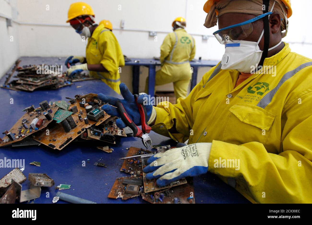 Employee sort out parts of discarded computers and other electronics for recycling at the East African Compliant Recycling (EACR) facility in Athi River near Kenya's capital Nairobi, March 7, 2014. The E-waste Solutions Alliance for Africa, a collaboration between Dell, HP, Nokia, Phillips and the recycler Reclaimed Appliances (UK) Ltd, has been working with key stakeholders and the Government of Kenya to develop the principles and processes needed for responsible collection and recycling of e-waste according to the EACR. REUTERS/Thomas Mukoya (KENYA - Tags: BUSINESS SCIENCE TECHNOLOGY EMPLOYM Stock Photo
