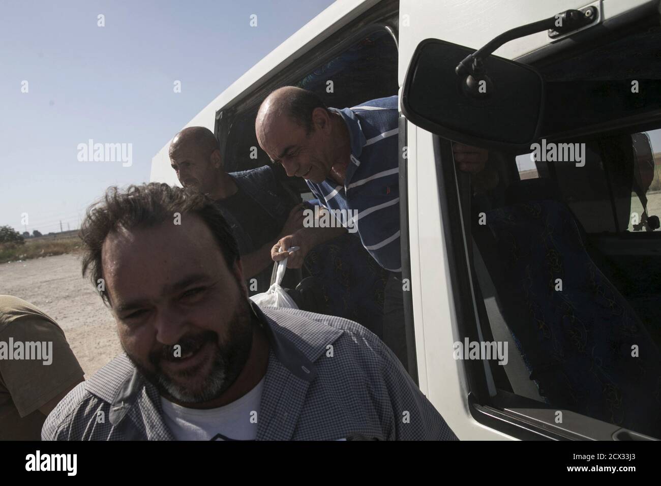 Palestinian labourers with permits to work in Israel step off a minibus as they return to the West Bank at Israel's Eyal checkpoint near the West Bank town of Qalqilya May 20, 2015. Prime Minister Benjamin Netanyahu suspended on Wednesday new bus travel and checkpoint regulations for Palestinian labourers only hours after they were imposed to an outcry by critics accusing Israel of racial segregation. REUTERS/Baz Ratner Stock Photo