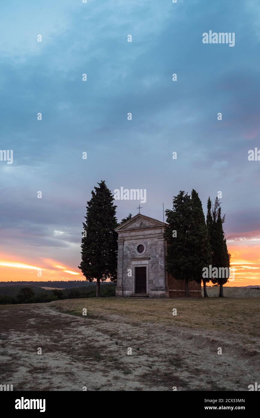 Chapel Cappella della Madonna di Vitaleta in Val d' Orcia, Tuscany, Italy at Sunrise or Dawn in the Romantic and Mysterious First Light Stock Photo
