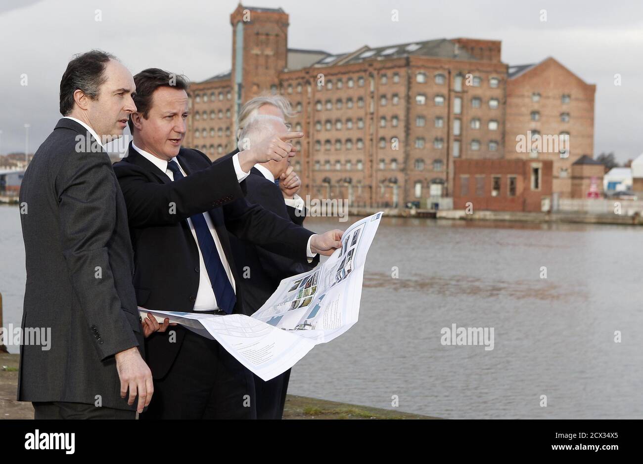 Britain's Prime Minister David Cameron (C) tours the £4.5 billion (6.9 billion US dollars) Wirral Waters development on Merseyside with Richard Mawdsley (L) and Peter Nears of Peel Holdings in Wirral, northwest England January 6, 2011. Britain's path to a sustainable recovery will be tough but is within reach, Prime Minister David Cameron said on Thursday, seeking to shift focus to enterprise and away from his tough agenda of tax hikes and spending cuts. REUTERS/Peter Byrne/POOL  (BRITAIN - Tags: POLITICS BUSINESS) Stock Photo