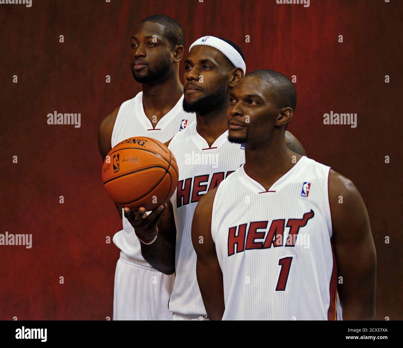 Miami Heat's Dwyane Wade (L), LeBron James (C) and Chris Bosh pose for  photographers during media day at the team's training camp in Miami,  Florida December 12, 2011. REUTERS/Hans Deryk (UNITED STATES -