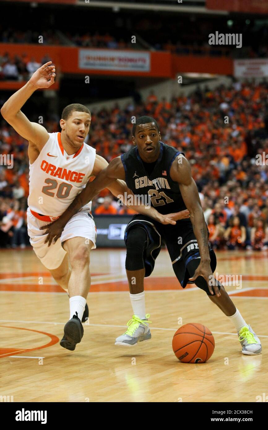 Georgetown Hoyas guard Jason Clark (R) dribbles down court against Syracuse  Orange guard Brandon Triche during the first half of their NCAA men's  basketball game in Syracuse, New York, February 8, 2012.