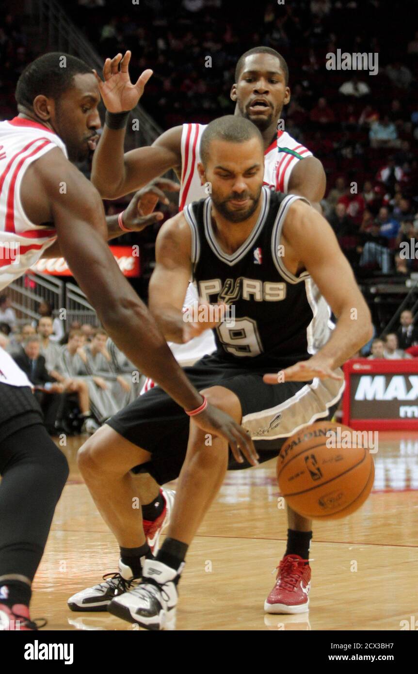 Houston Rockets center Patrick Patterson (L) and guard Toney Douglas  double-team San Antonio Spurs guard Tony Parker (front R) during the first  half of their NBA basketball game in Houston December 10,