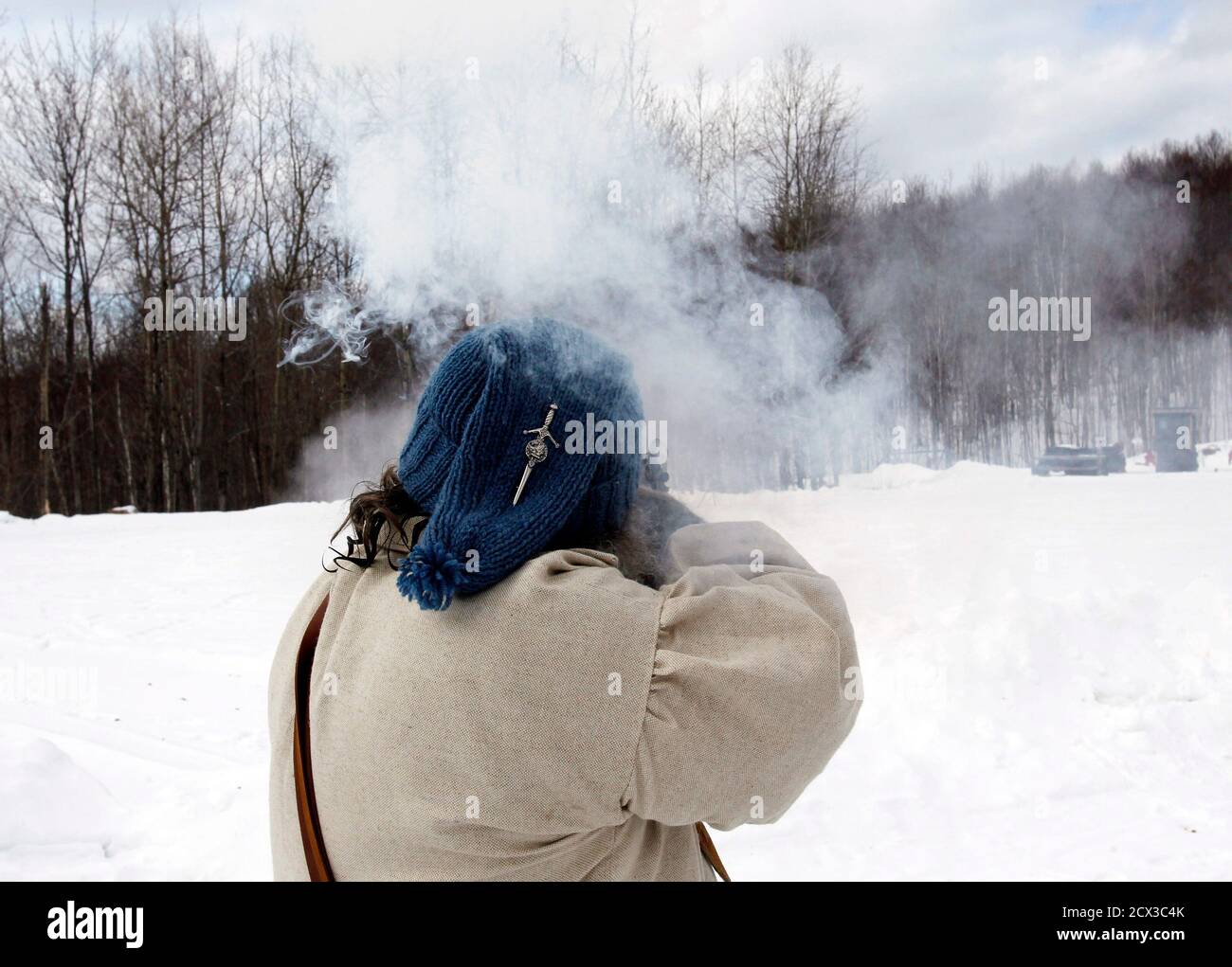 Don Campbell fires at a target as he competes in the Primitive Biathlon in Dalton, New Hampshire February 16, 2013. The Dalton Gang, a single action shooting club, holds the annual Primitive Biathlon in which competitors wear snowshoes and fire single shot muzzle loaded firearms at four stations along a 1.75 mile course. REUTERS/Jessica Rinaldi (UNITED STATES - Tags: SOCIETY SPORT) Stock Photo