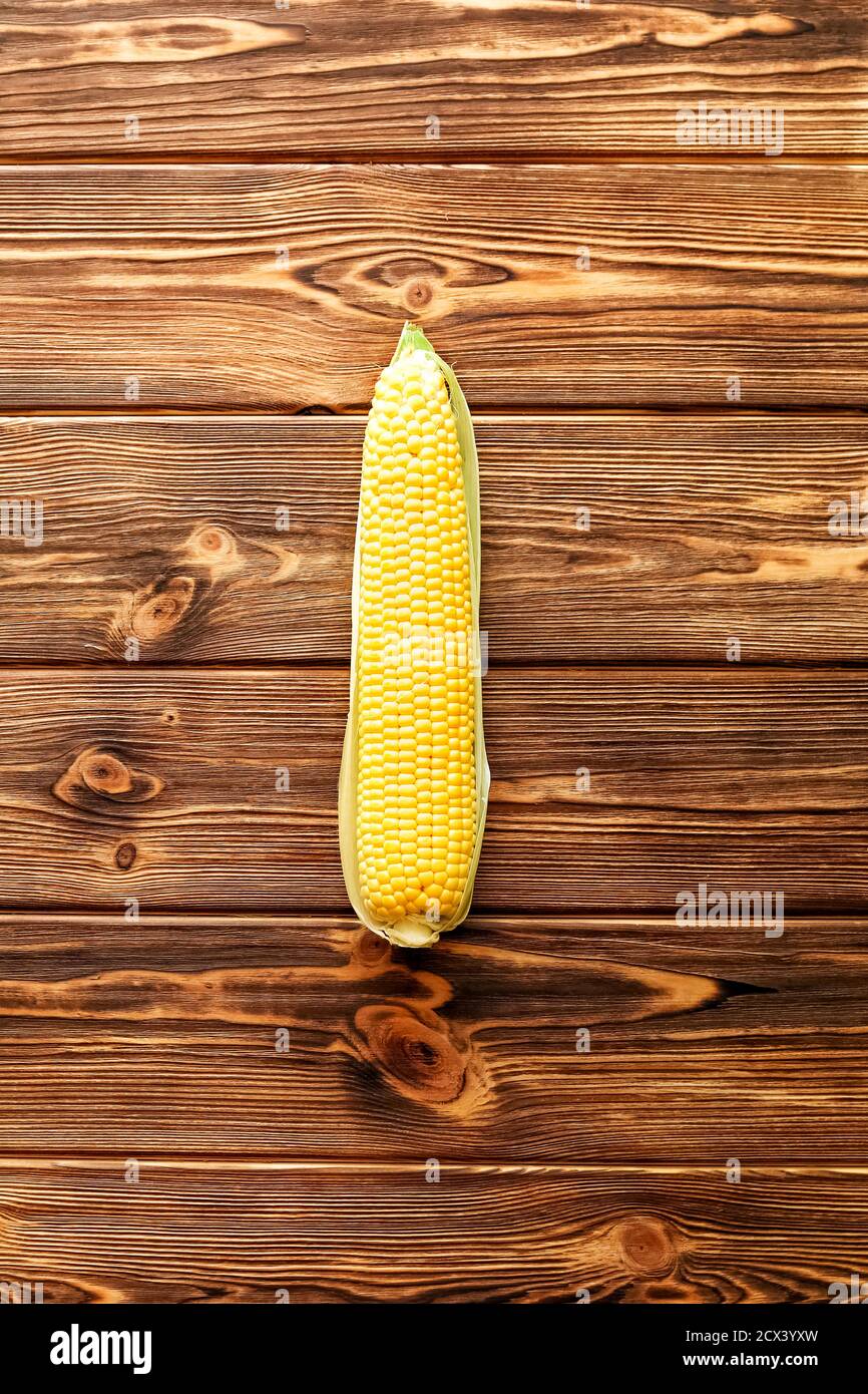 Fresh corn on cob on rustic wooden table. Top view. Stock Photo