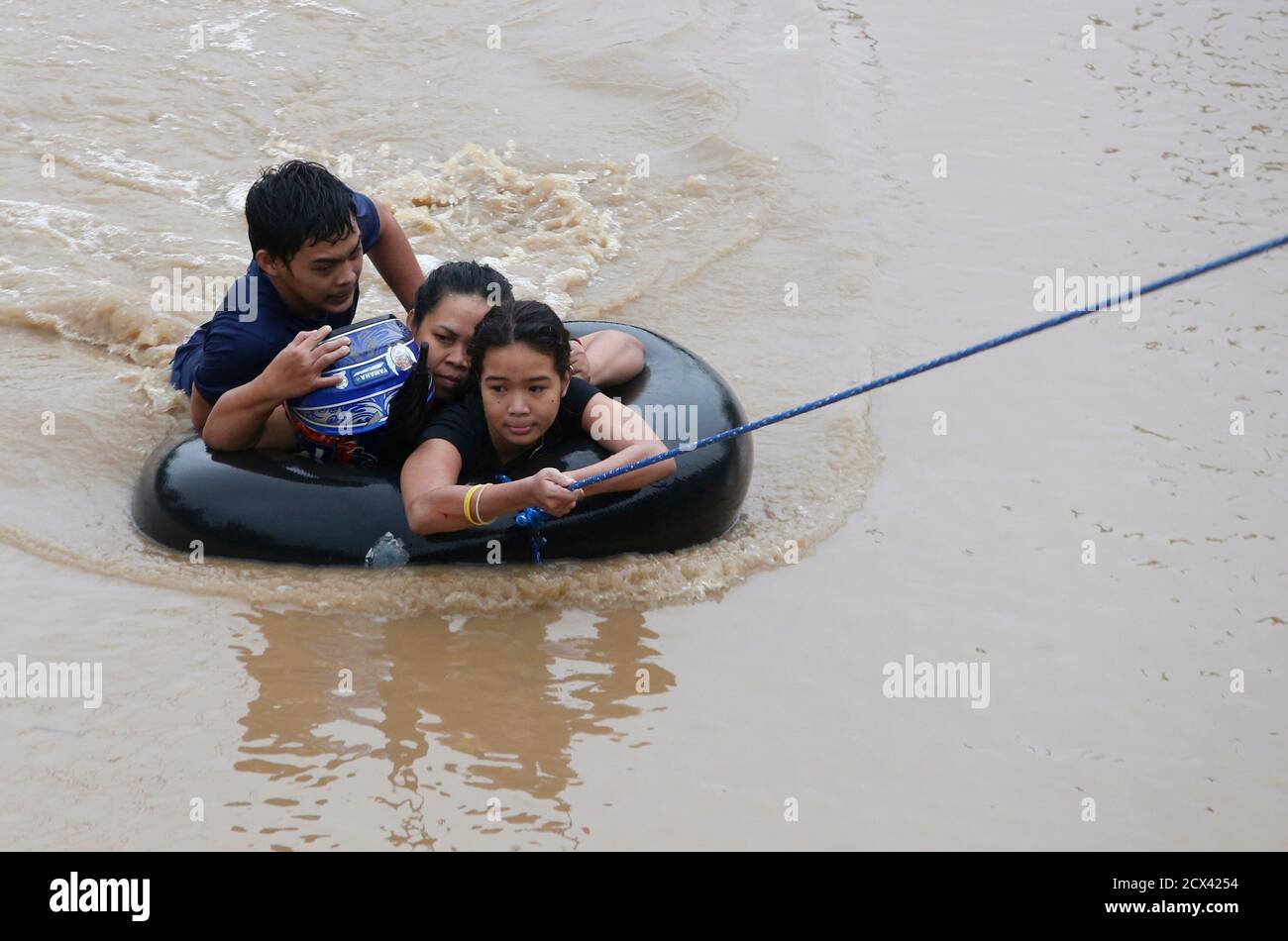 Flood victims are pulled on an inflatable tire tube as they are evacuated from heavy flooding brought by tropical depression 'Agaton' in Butuan, in the southern Philippine island of Mindanao January 20, 2014. Floods and landslides caused by tropical depression 'Agaton'  have killed 40 people and more than 500,000 people are displaced in Mindanao, the National Disaster Risk Reduction and Management Council reported on Sunday.   REUTERS/Erik De Castro (PHILIPPINES - Tags: DISASTER ENVIRONMENT) Stock Photo