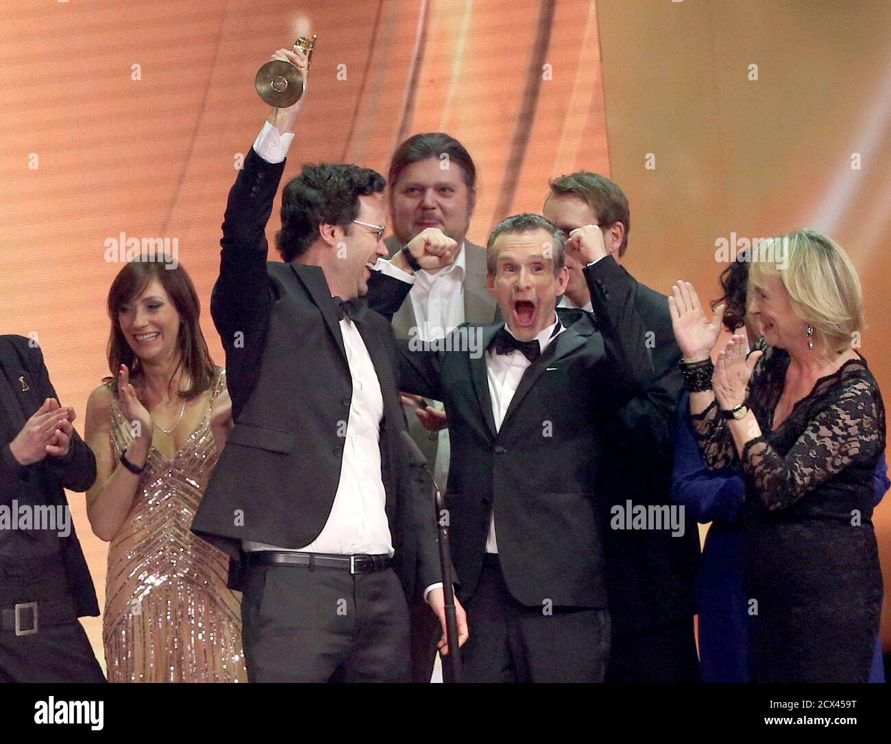 Director Florian Schwarz celebrates next to actor Ulrich Matthes (2R) and other cast members of TV series 'Tatort' as they received the award for Best TV Film for the episode 'Tatort: Im Schmerz geboren' (Tatort: Born in Pain) at the 'Die Goldene Kamera' (Golden Camera) awards ceremony in Hamburg, February 27, 2015. The Golden Cameras are awarded by a popular German TV magazine honouring excellence in the areas of television, film and entertainment.             REUTERS/Christian Charisius/Pool (GERMANY  - Tags: ENTERTAINMENT) Stock Photo