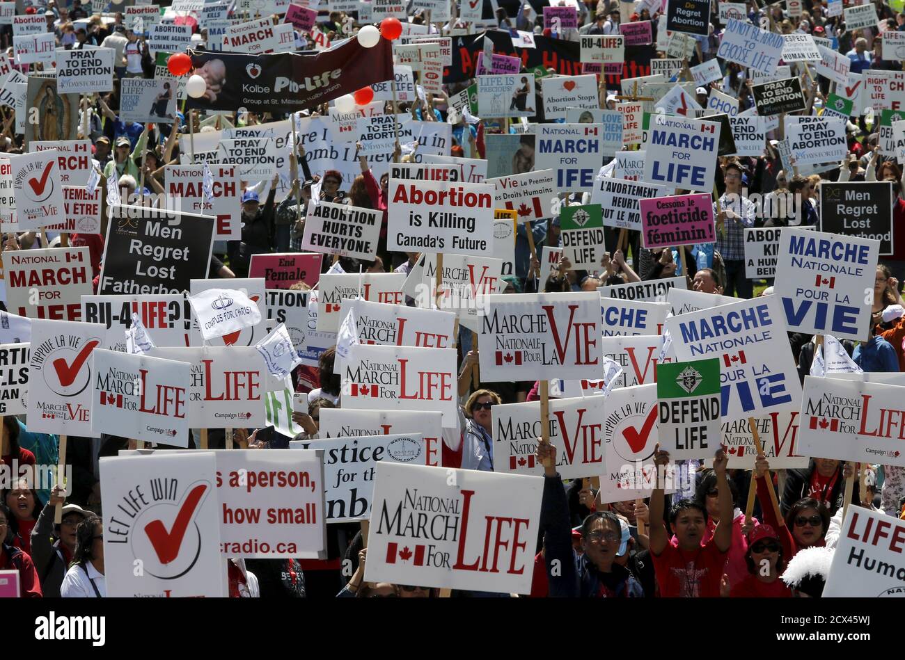 Demonstrators hold signs during an anti-abortion protest on Parliament Hill in Ottawa May 14, 2015. REUTERS/Chris Wattie Stock Photo