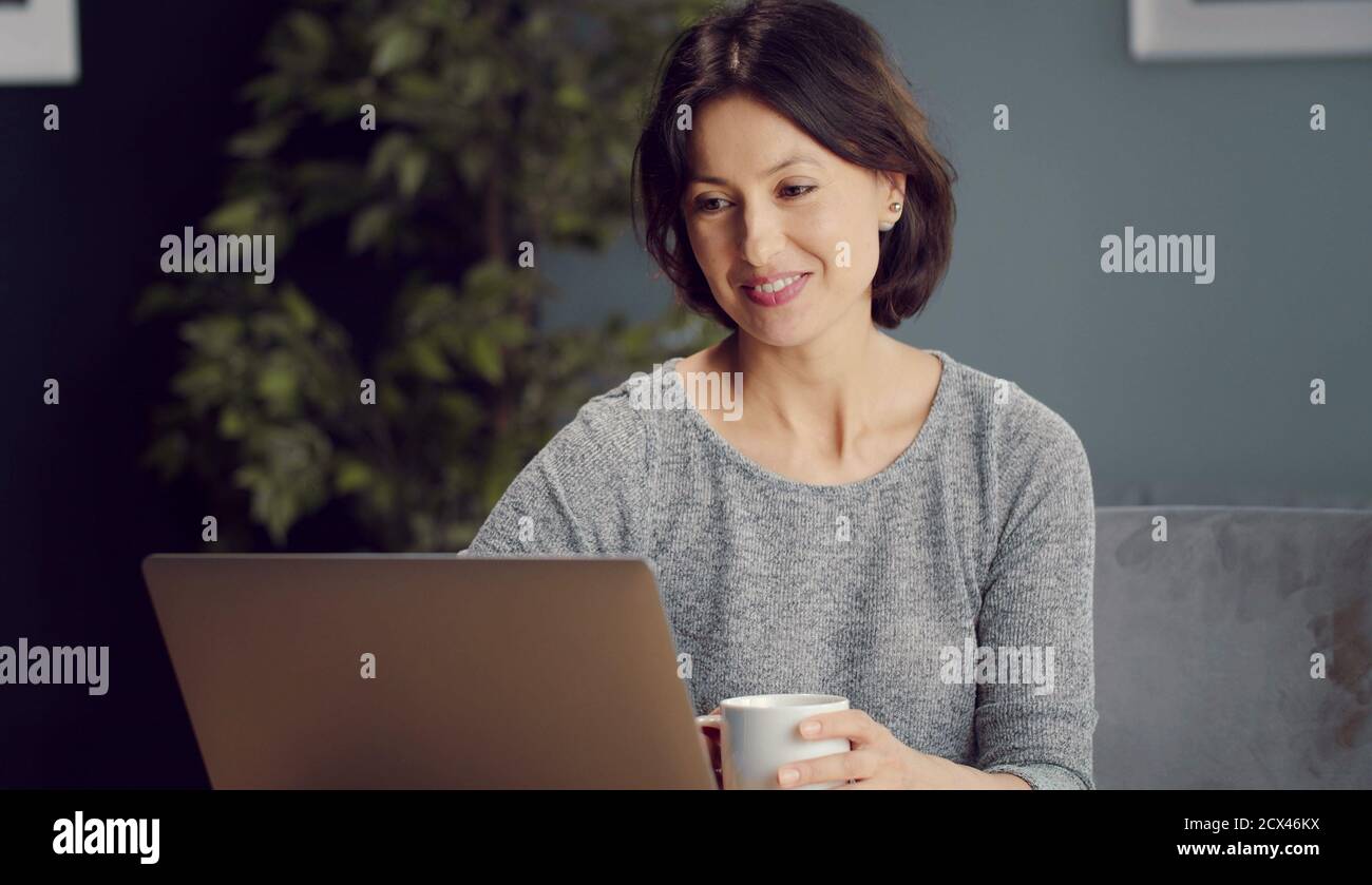 Smiling woman looking laptop screen Stock Photo