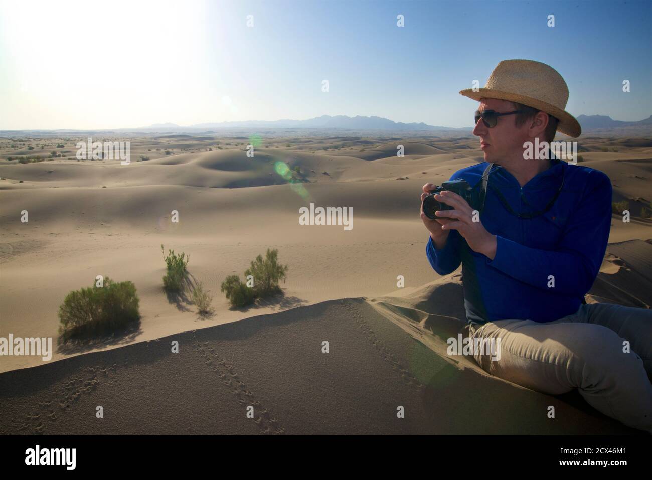 Western traveller photographing the sand dunes at Mesr, near Khur in central Iran. The Kavir desert. Dasht-e Kavir. Model Released. Stock Photo