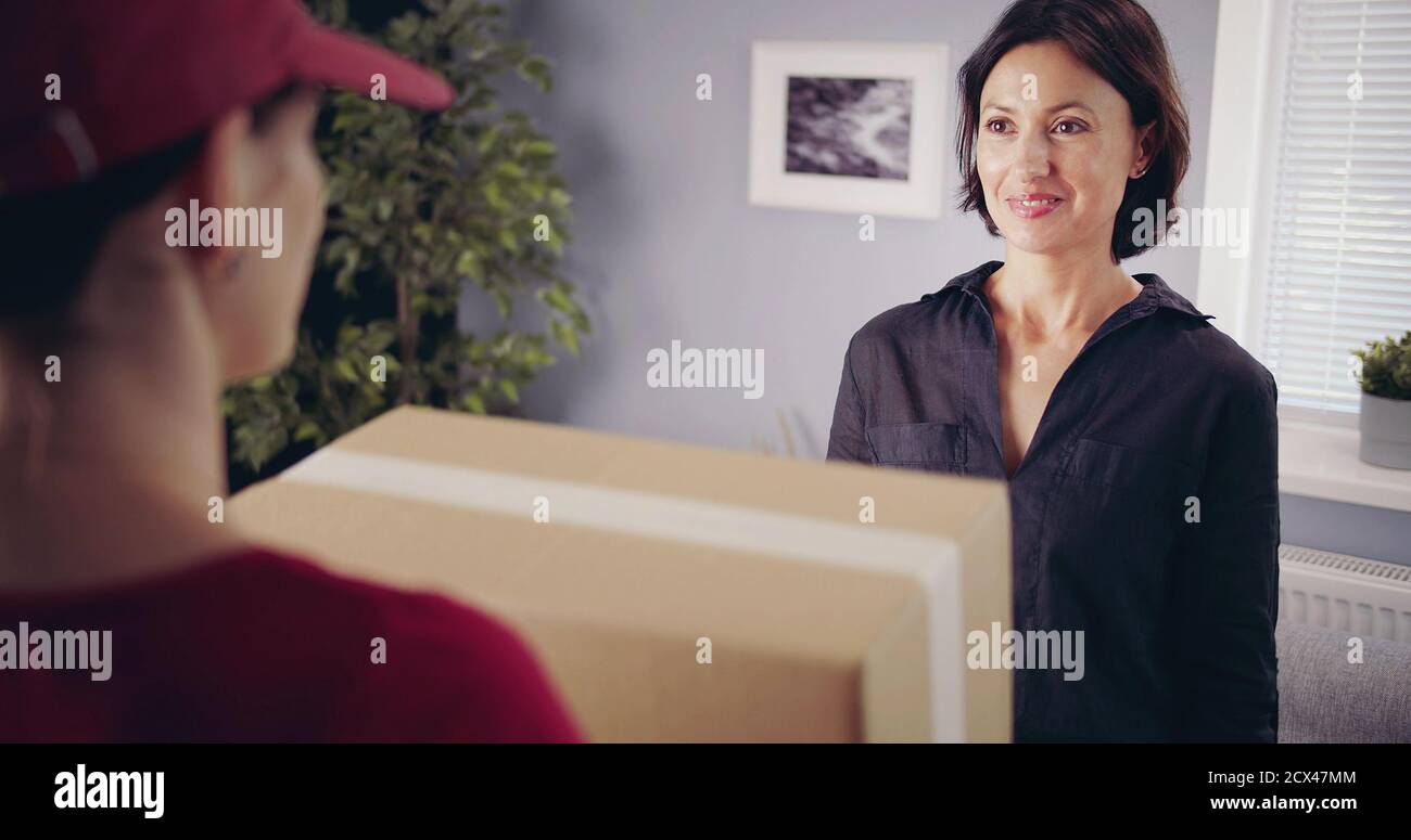 Brunette looking deliveryman holding box Stock Photo