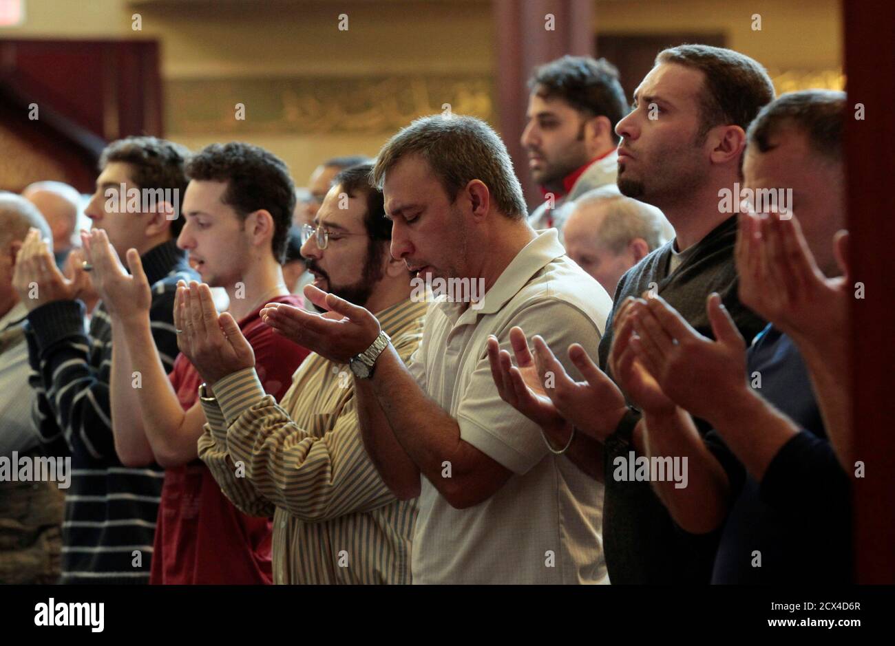 Muslim-American men pray during afternoon prayers at the Islamic Center of America before attending a peaceful  interfaith rally against the violence triggered by a privately made anti-Islam video in Dearborn, Michigan September 21, 2012.    REUTERS/Rebecca Cook  (UNITED STATES - Tags: RELIGION CIVIL UNREST) Stock Photo