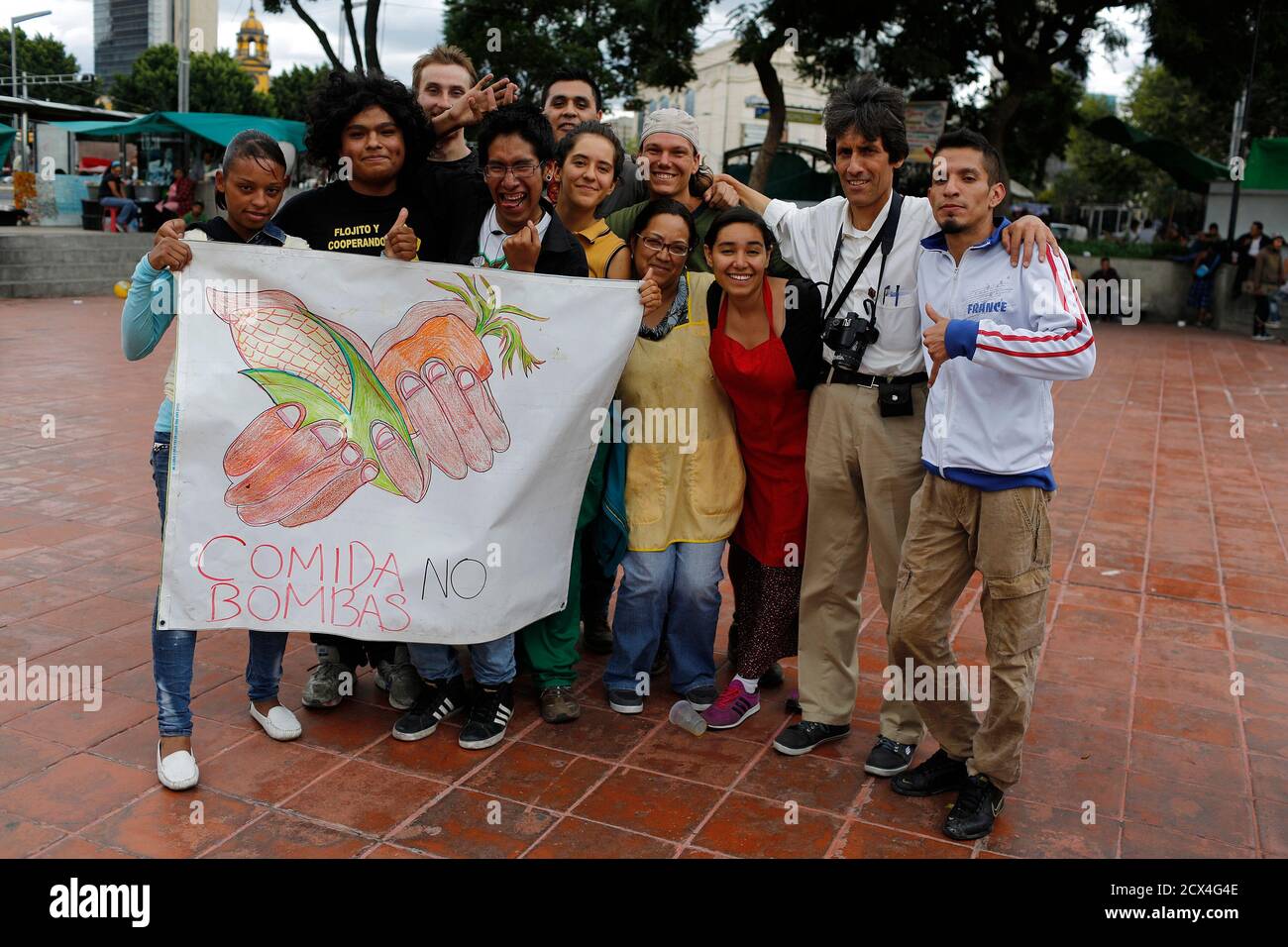 Activists of Comida No Bombas (Food, Not Bombs) and homeless people pose for a picture at Francisco Zarco plaza in Mexico City August 25, 2013. Comida No Bombas collects unwanted produce which is still edible from private donations, markets and shops, and distributes them freely as cooked dishes to the public in over a thousand cities around the world, as a form of protest against war, poverty and the destruction of the environment. Picture taken August 25, 2013. REUTERS/Tomas Bravo (MEXICO - Tags: SOCIETY FOOD POVERTY) Stock Photo