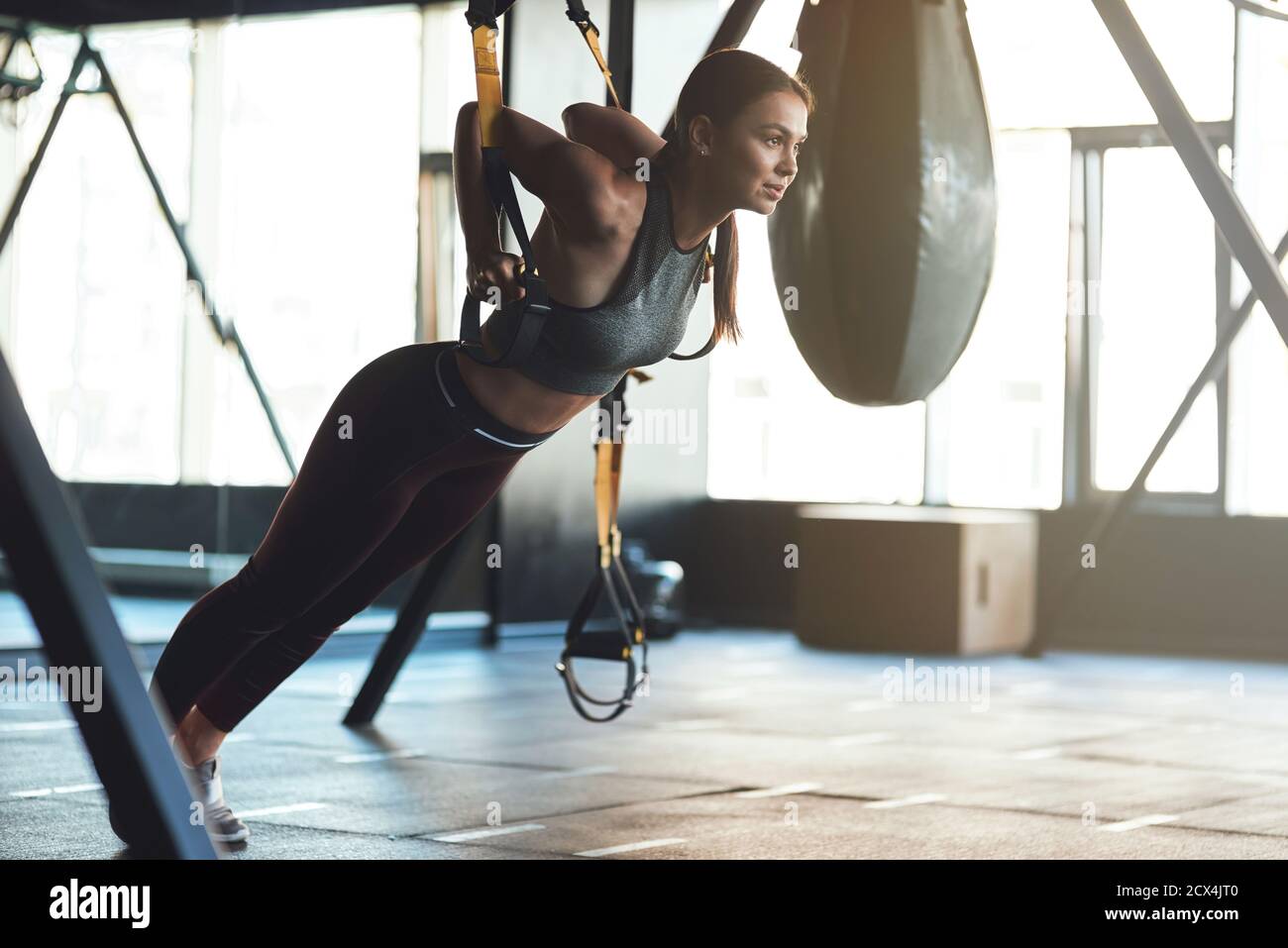 Young beautiful athletic woman wearing sports clothes exercising with  fitness trx straps, doing push ups while training at gym. Sport, workout,  wellness and healthy lifestyle Stock Photo - Alamy