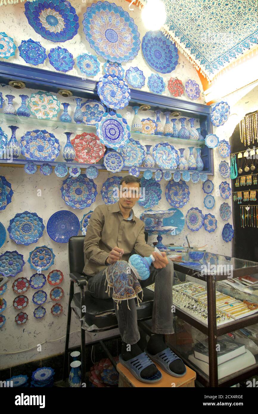 Iranian artist decorating Persian ceramic vases with blue enamel. Bazaar, Isfahan, Iran Stock Photo
