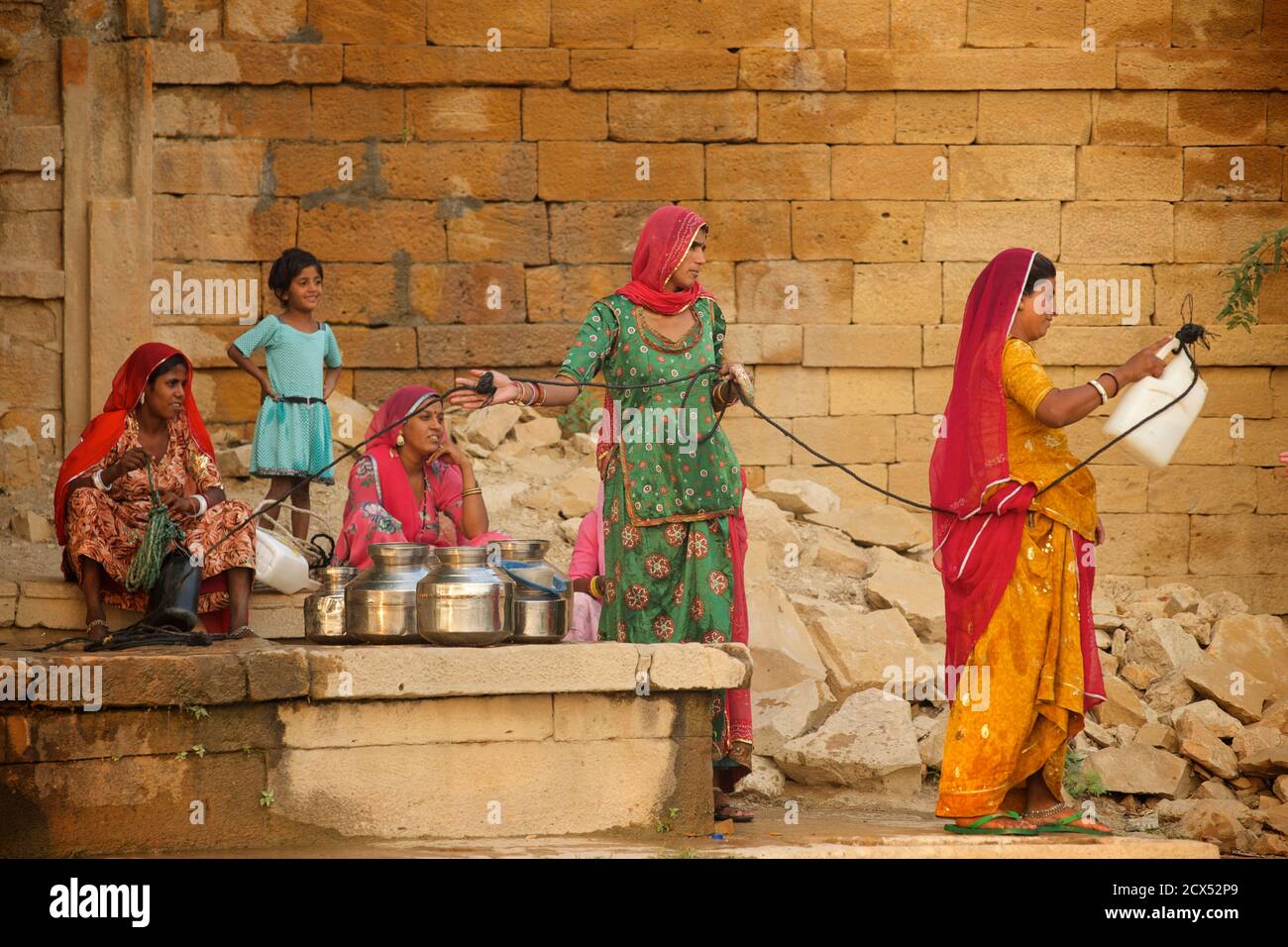 Rajasthani women collecting water from a well at Amar Sagar, Lodurva, nr Jaisalmer, Rajasthan, India Stock Photo