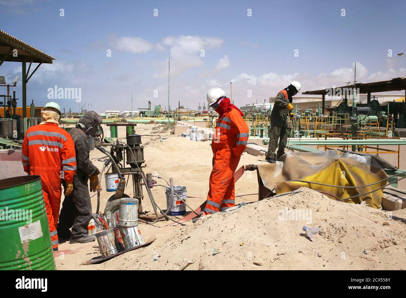 Workers conduct maintenance work on oil pipelines at the Zueitina oil terminal in Zueitina, west of Benghazi April 7, 2014. Libya's Zueitina oil port prepared on Monday to load crude on tankers after the government reached a deal with rebels to reopen four terminals that insurgents have occupied since summer. The federalist rebels agreed on Sunday to end gradually their eight-month blockade of Zueitina, Hariga, Ras Lanuf and Es Sider ports, which account for around 700,000 barrels per day of the OPEC country's crude exports. REUTERS/Esam Omran Al-Fetori (LIBYA  - Tags: POLITICS ENERGY BUSINESS Stock Photo