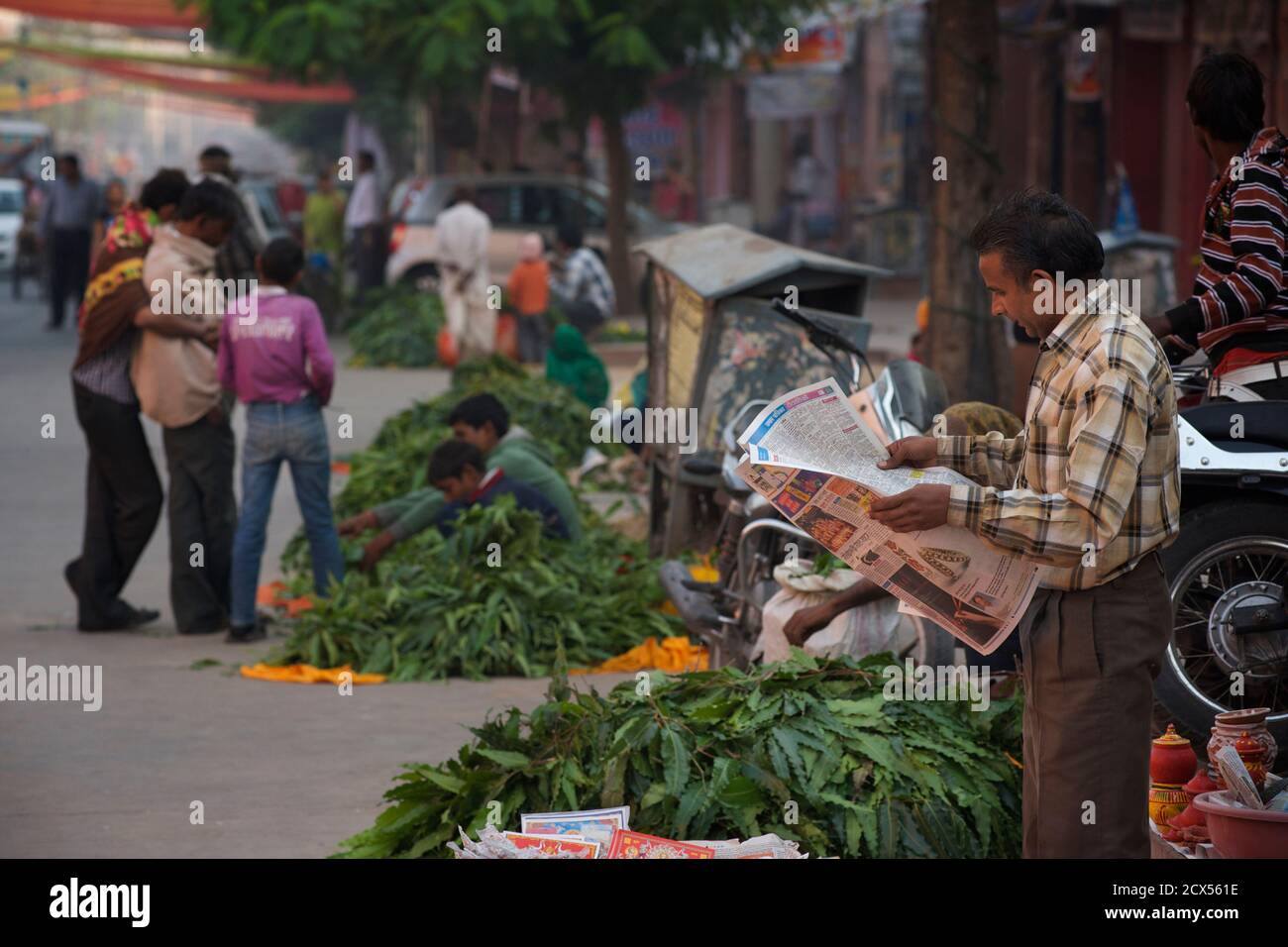 Indian street vendors and man reading newspaper, Jaipur, Rajasthan, India Stock Photo