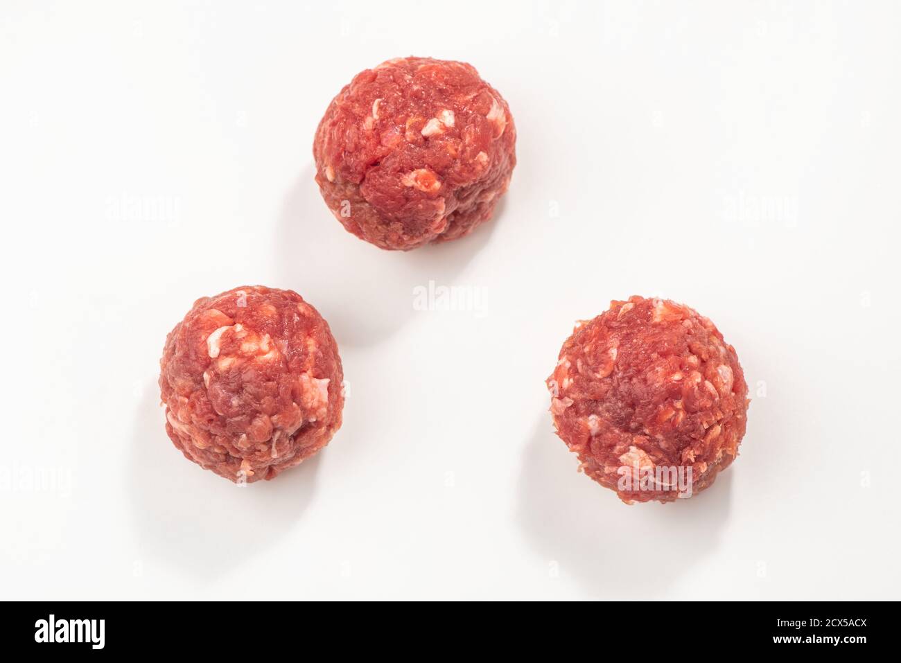 Top view on three raw meatballs on white background Stock Photo