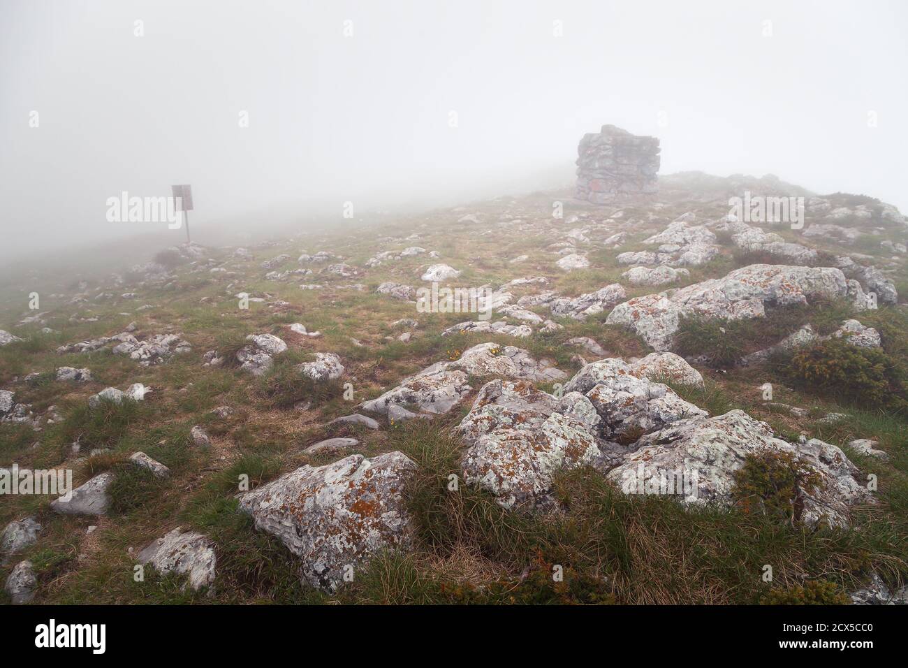 Foggy view of Trem summit stone and sign on Dry mountain (Suva planina) on a misty, wet, moody morning Stock Photo