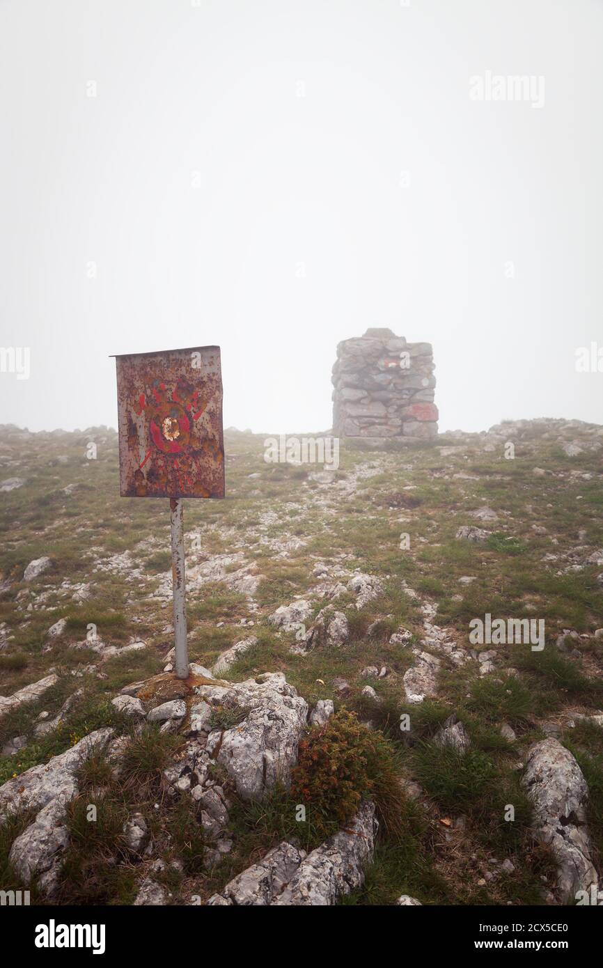 Foggy view of Trem summit stone and sign on Dry mountain (Suva planina) on a misty, wet, moody morning Stock Photo