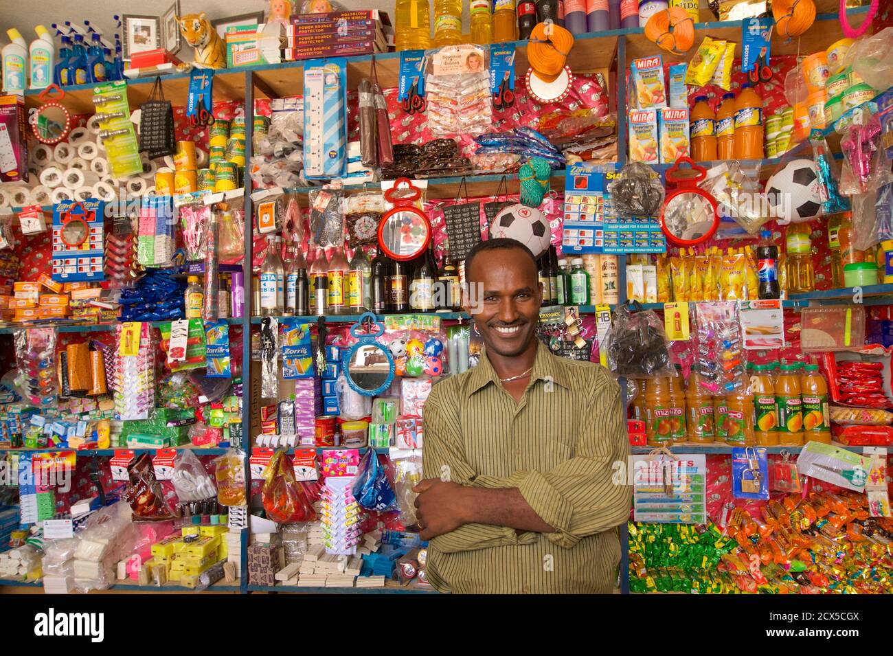Ethiopian shopkeeper proudly stands in his shop surrounded by goods