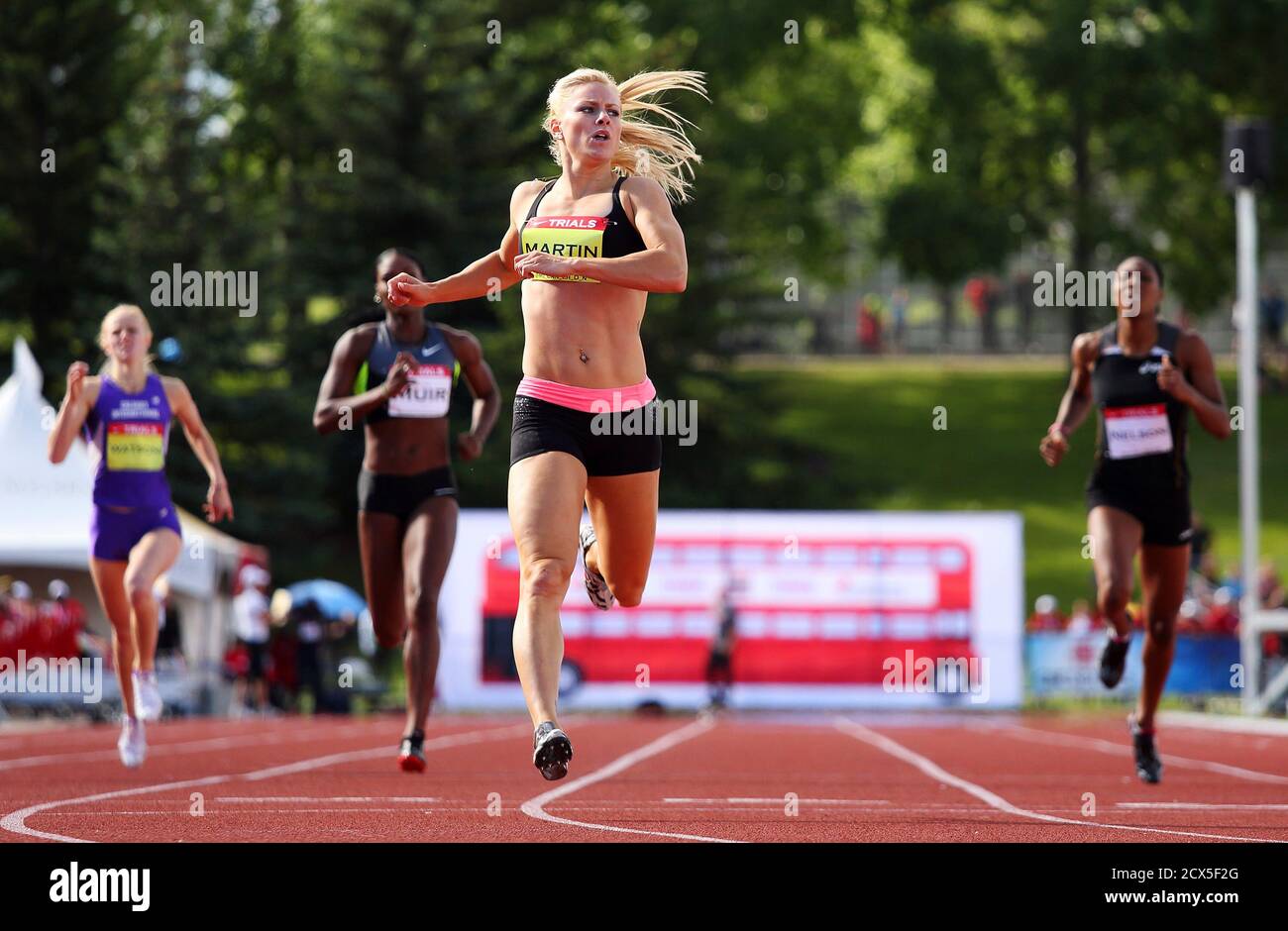 Jenna Martin (C) crosses the finish line to win the women's 400 meter race at the Canadian Track