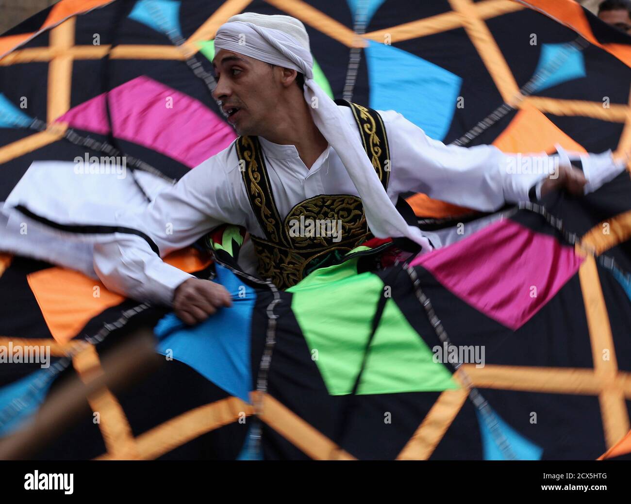 A whirling dervish performs a traditional dance on the famous Al-Moez Street, considered the largest open museum of historical Islamic monuments in Egypt, in Cairo March 16, 2013. REUTERS/Asmaa Waguih (EGYPT - Tags: SOCIETY) Stock Photo