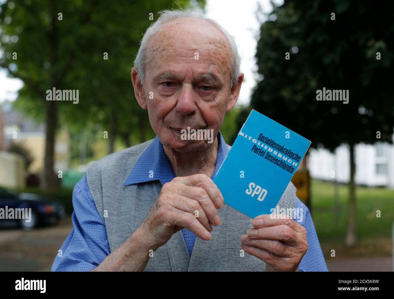 Rudolf Oeser, a member of Germany's Social Democratic party (SPD) party  poses with his member card at his retirement home in the western city of  Hamm August 13, 2013. The 95-year-old has