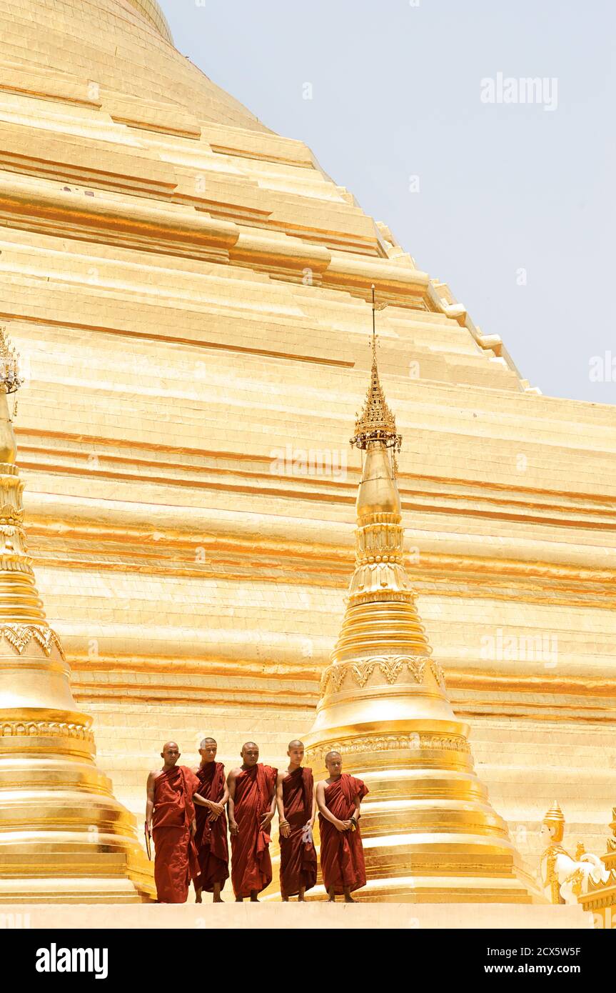 Monks standing beside stupa of Shwedagon Pagoda, Rangoon, Burma Stock Photo
