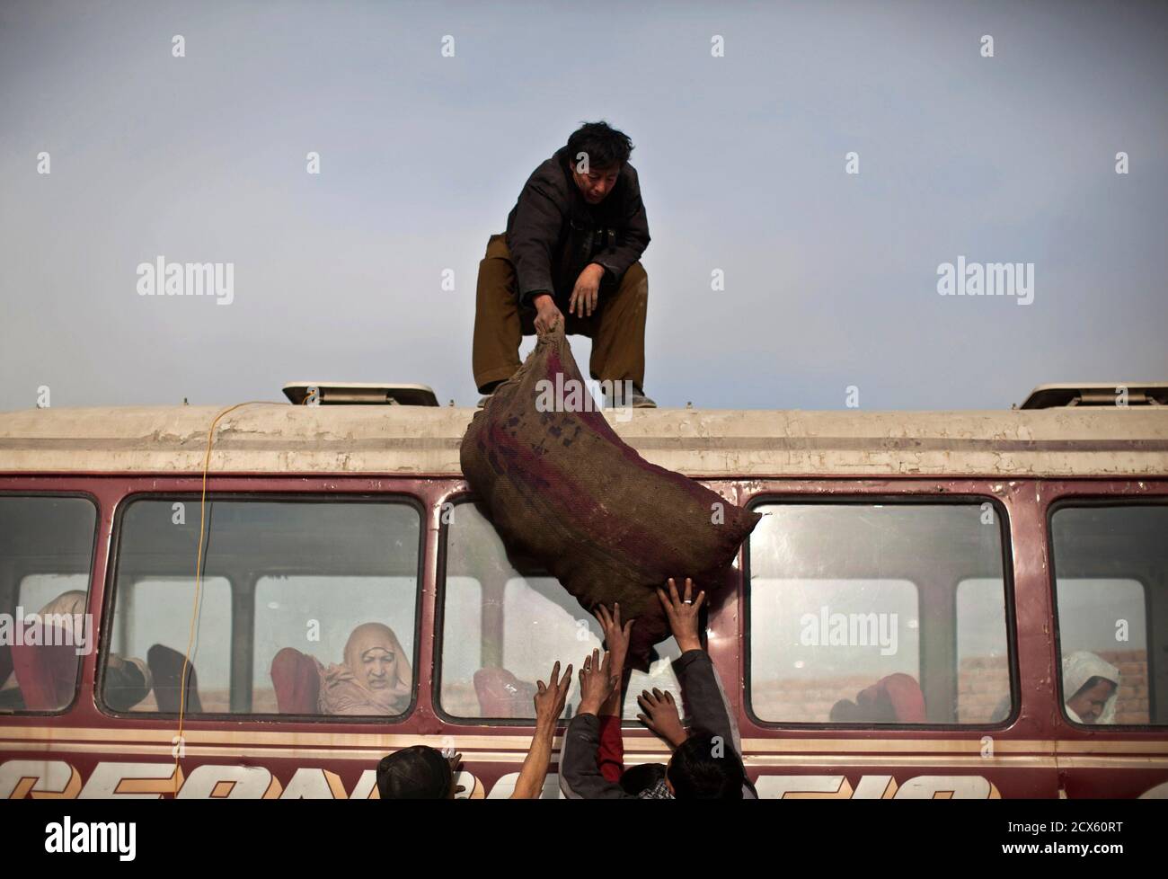 Men Load A Sack Of Coal On Top Of A Mini Bus For Transportation During The Distribution Of Winter Assistance In Kabul By The Un Refugee Agency For The Most Vulnerable Returnees Internally