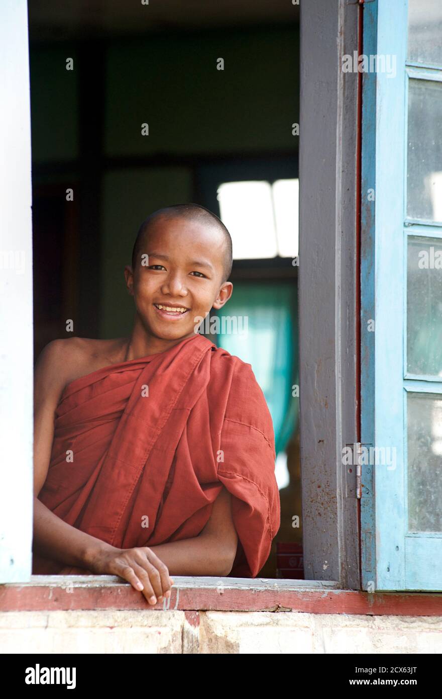Novice monk at the window to his monastery quarters, Sasana Pagoda. Pyilon Chanta. Lashio, Burma Stock Photo