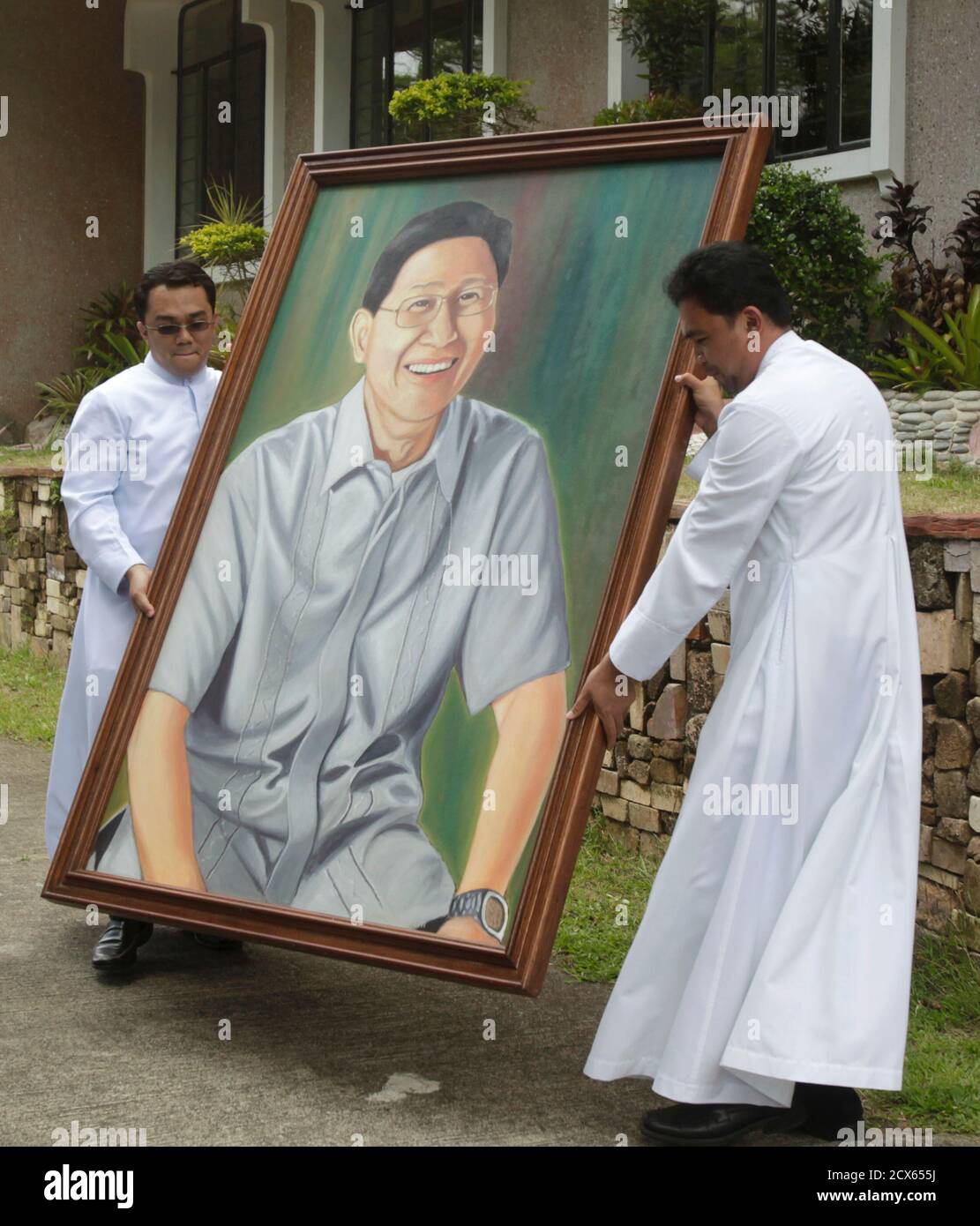 Seminarians of Tahanan ng Mabuting Pastol (Home of the Good Shepherd) carry a large portrait of Cardinal Luis Antonio Tagle outside their seminary in Tagaytay city, south of Manila February 27, 2013. The seminarians gave the portrait to Tagle who had been their rector for 11 years before being elected cardinal. Tagle, 55, who became a cardinal only in November 2012, is among those mentioned as a possible successor to Pope Benedict XVI after his resignation. Picture taken February 27, 2013. REUTERS/Erik De Castro  (PHILIPPINES - Tags: RELIGION POLITICS) Stock Photo