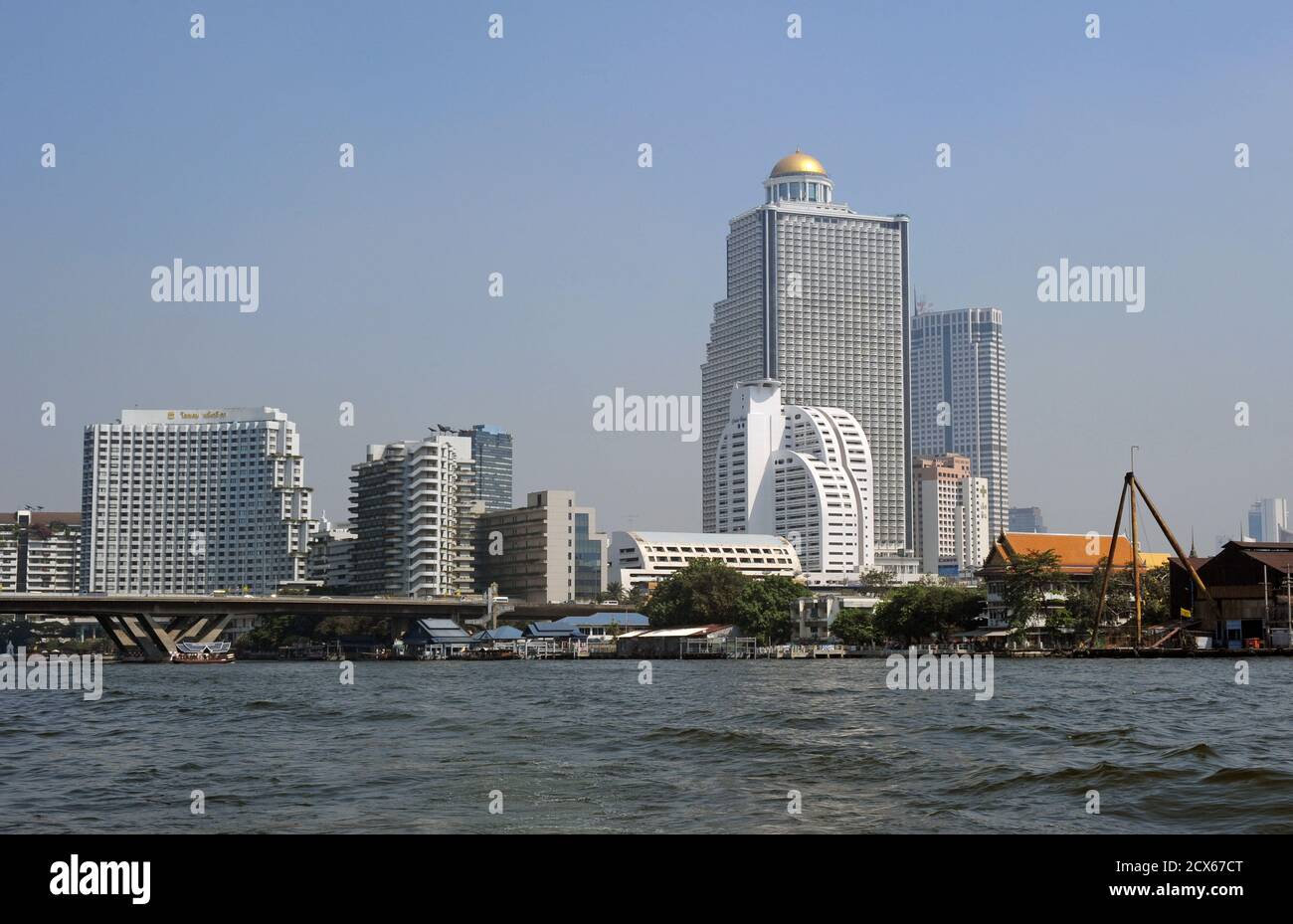 The Chao Phraya River, Bangkok. High rise development including the dome-topped State Tower, the second tallest building in Thailand. The rooftop Sirocco restaurant and 'Sky Bar', on the 63rd floor.  Thailand Stock Photo