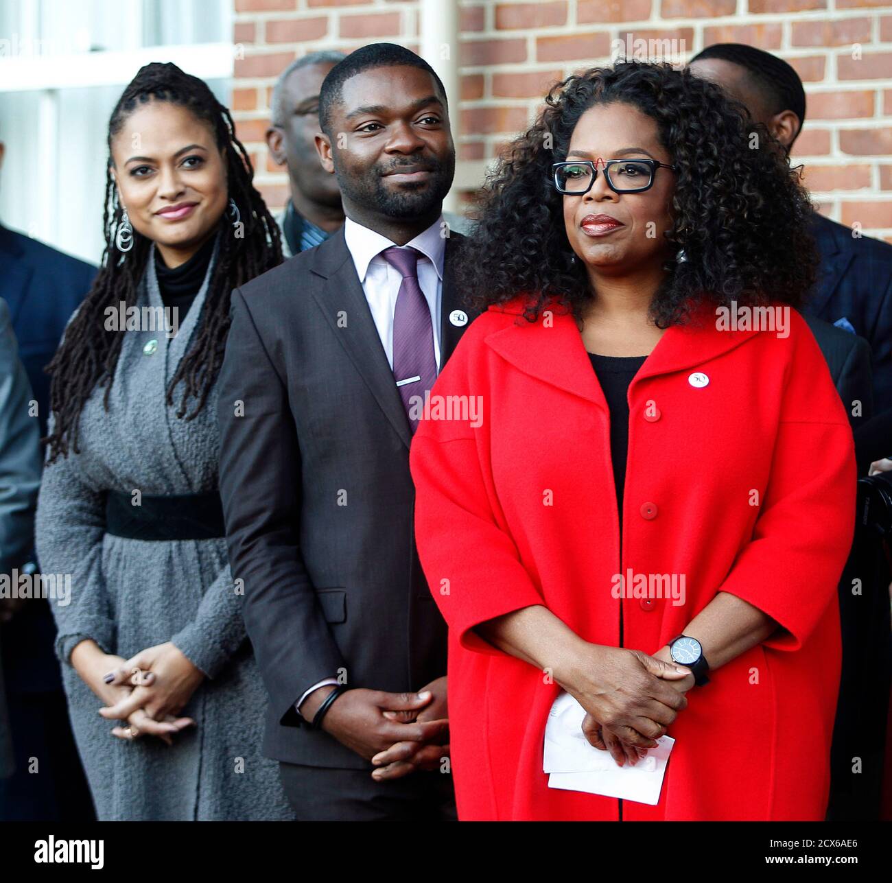 Producer and cast member Oprah Winfrey (R), fellow "Selma" actor David  Oyelowo (C), and director Ava DuVernay (L) listen to an address to  residents at City Hall in Selma, Alabama January 18,