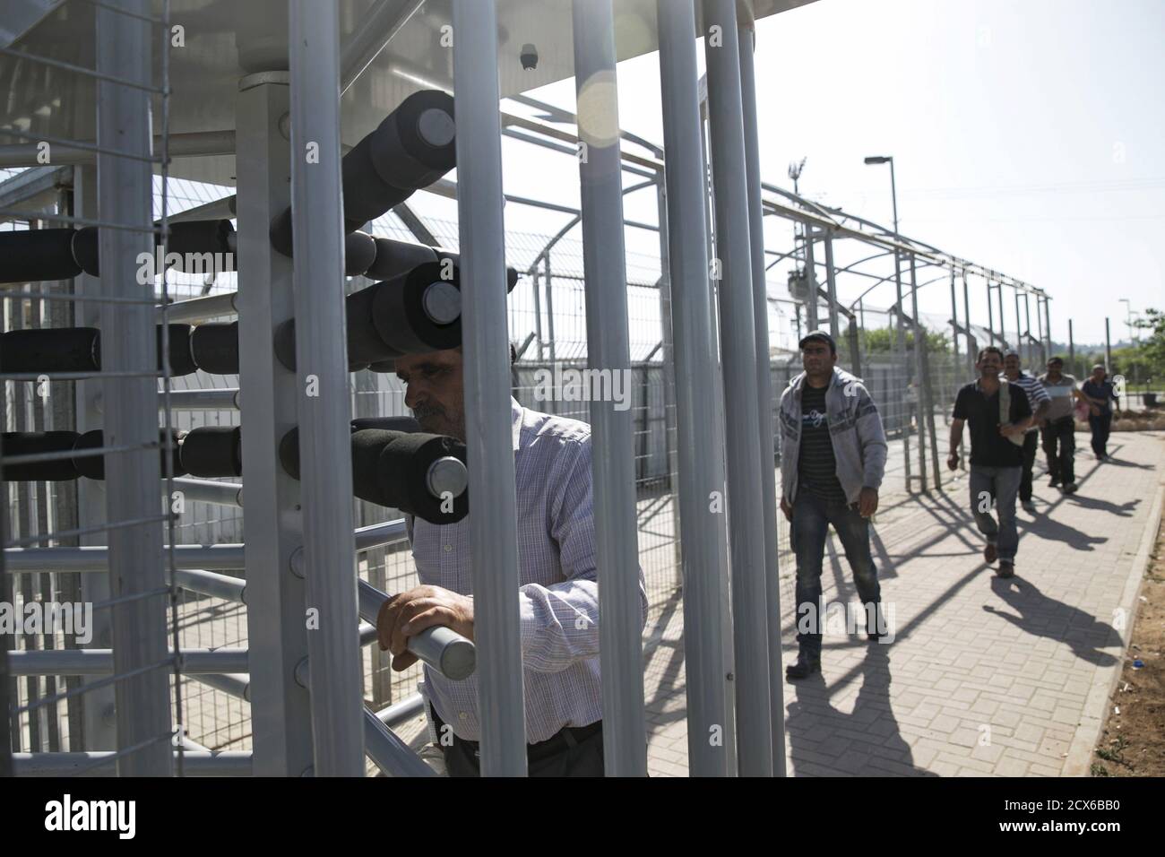 Palestinian labourers with permits to work in Israel walk through a turnstile as they return to the West Bank at Israel's Eyal checkpoint near the West Bank town of Qalqilya May 20, 2015. Prime Minister Benjamin Netanyahu suspended on Wednesday new bus travel and checkpoint regulations for Palestinian labourers only hours after they were imposed to an outcry by critics accusing Israel of racial segregation. REUTERS/Baz Ratner Stock Photo