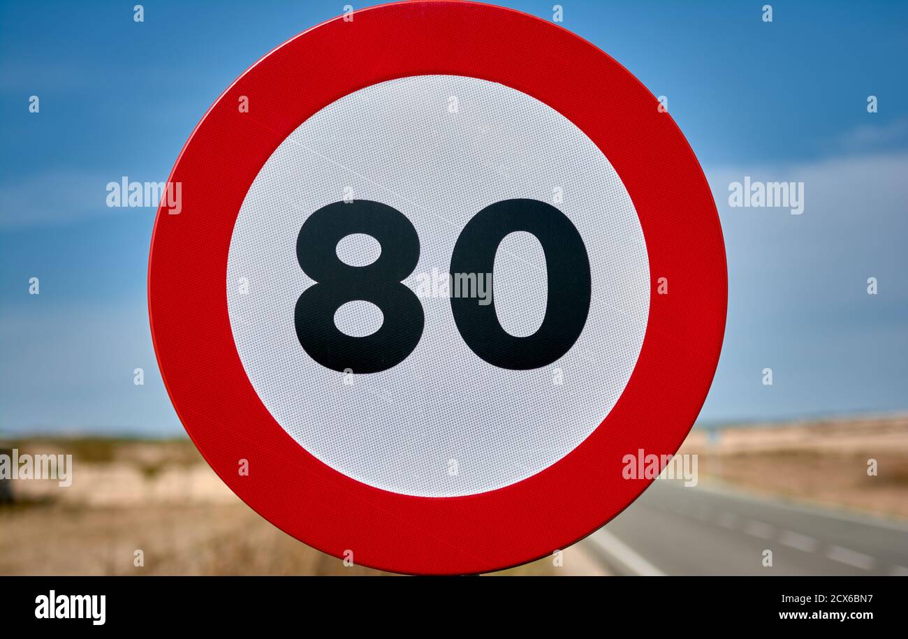 detail of a round traffic sign with red border and black limit number 80 km/h mph Stock Photo