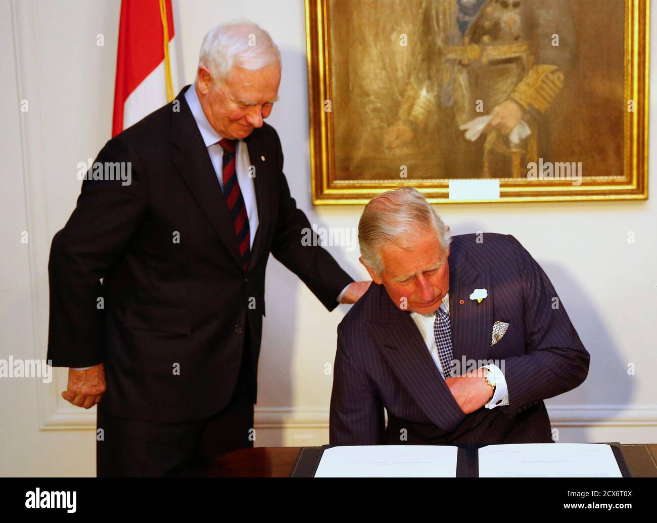 Britain's Prince Charles (R) sits down to sign a document to be sworn in as a member of the Canadian Privy Council beside Governor General of Canada David Johnson in Halifax, Nova Scotia May 18, 2014. The royal couple are on a four-day visit to Canada that begins in Halifax and includes stops in Pictou, Nova Scotia, the Prince Edward Island towns of Charlottetown, Bonshaw and Cornwall and concludes in Winnipeg. REUTERS/Mark Blinch (CANADA - Tags: ROYALS SOCIETY ENTERTAINMENT) Stock Photo