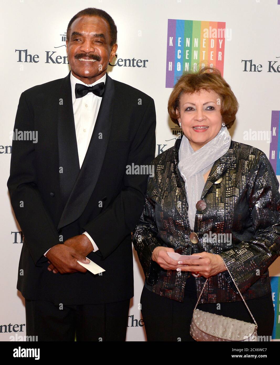 Former NFL running back Calvin Hill and his wife Janet pose for photographers on the red carpet as they arrive ahead of the 37th Annual Kennedy Center gala dinner at the U.S. State Department in Washington December 6, 2014. This year's show will toast actor Tom Hanks, recording artists Sting and Al Green, ballerina Patricia McBride, and actress Lily Tomlin, 'for their lifetime contributions to American culture.'       REUTERS/Mike Theiler (UNITED STATES - Tags: ENTERTAINMENT POLITICS SPORT FOOTBALL) Stock Photo